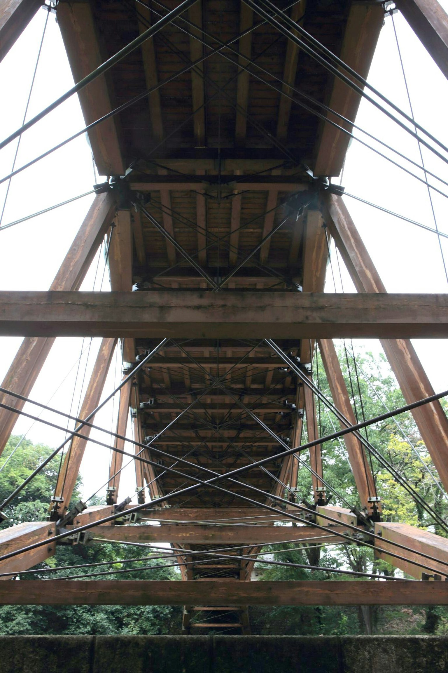 Di bawah jembatan kayu yang menunjukkan desain strukturnya