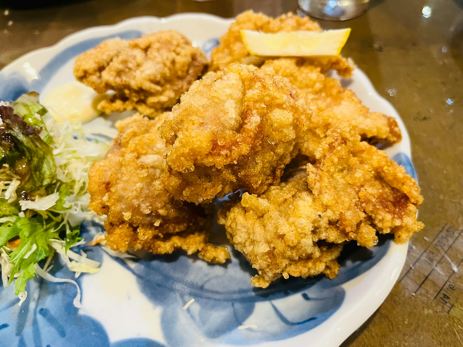 一盘美味的炸鸡块，配有生菜和柠檬