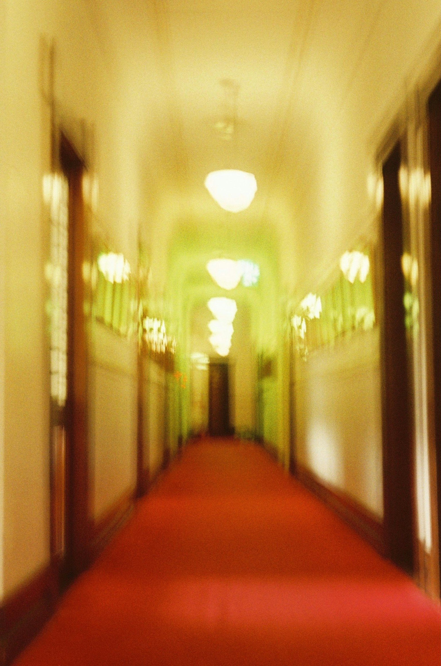 Immagine sfocata di un corridoio con moquette rossa e luci verdi