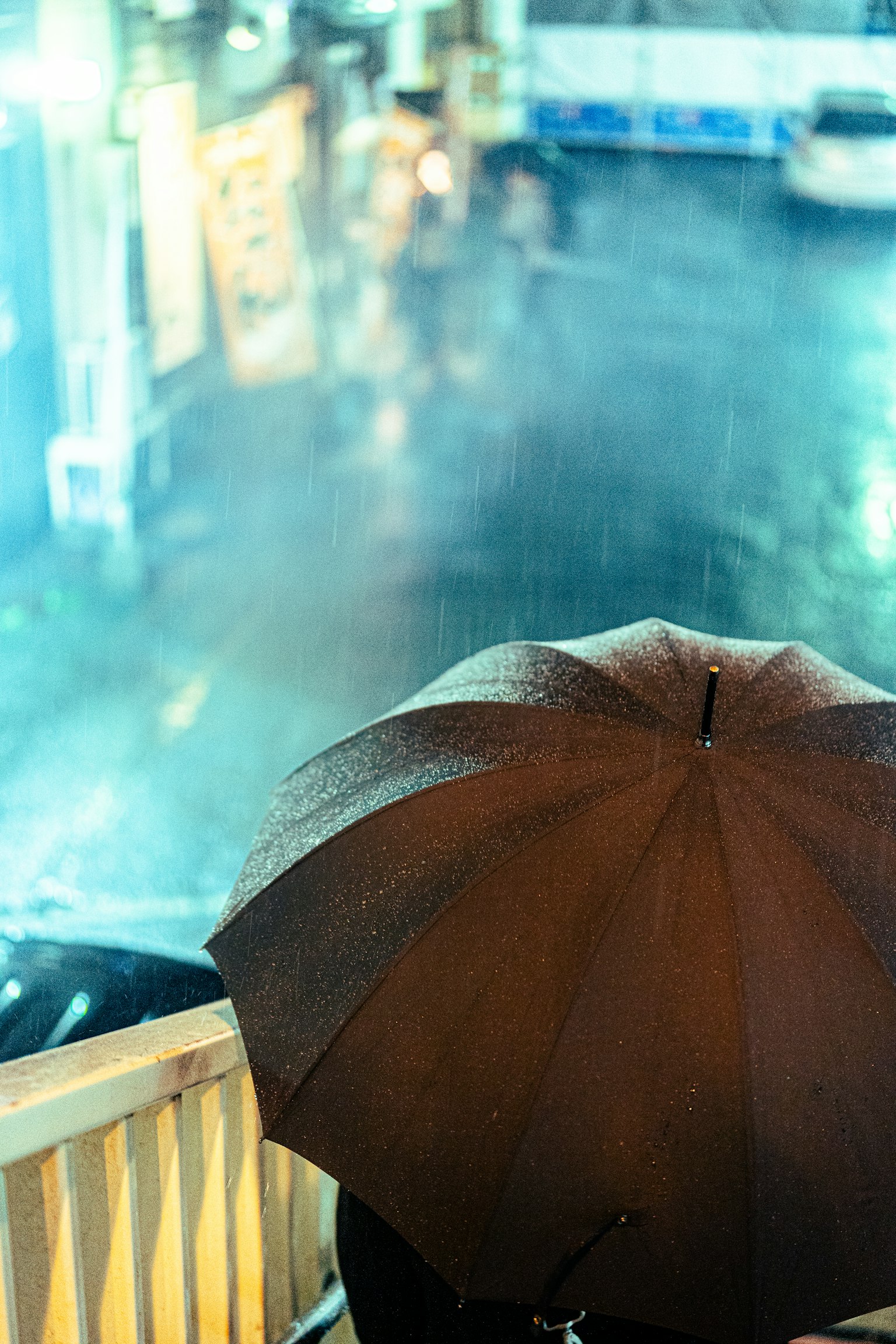 雨中黑傘與模糊城市背景