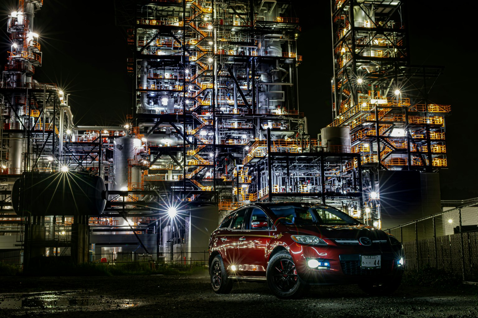 夜間停在工業建築前的紅色SUV