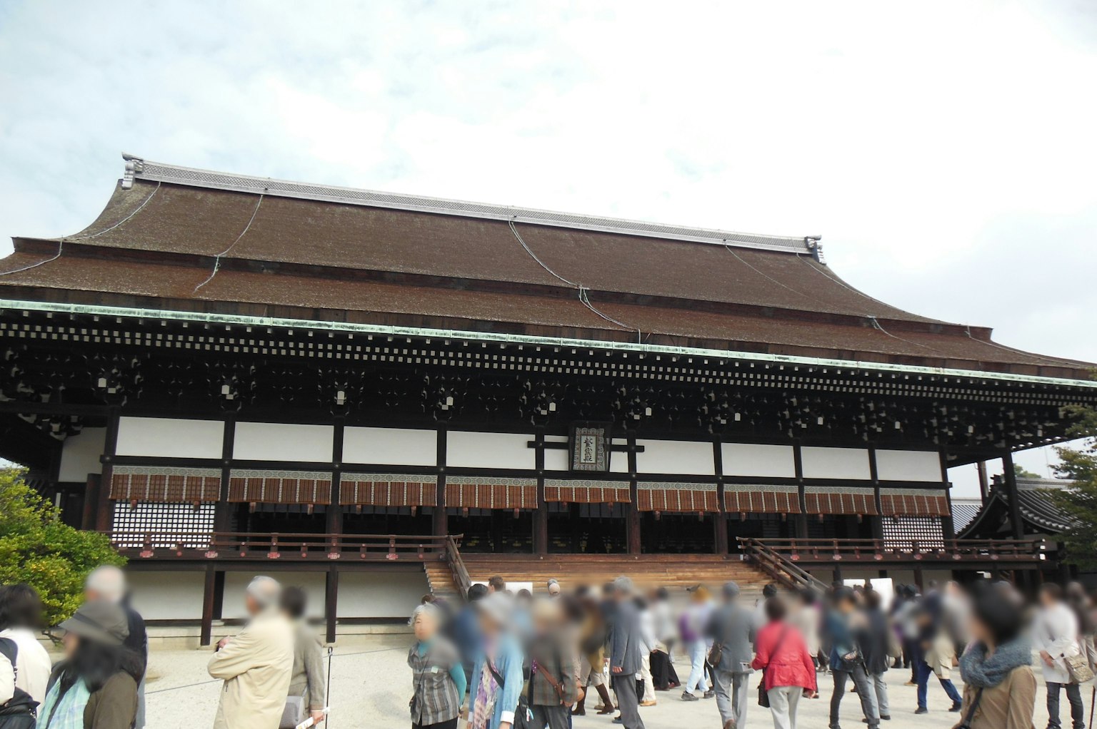 Traditional building in Kyoto with people walking by