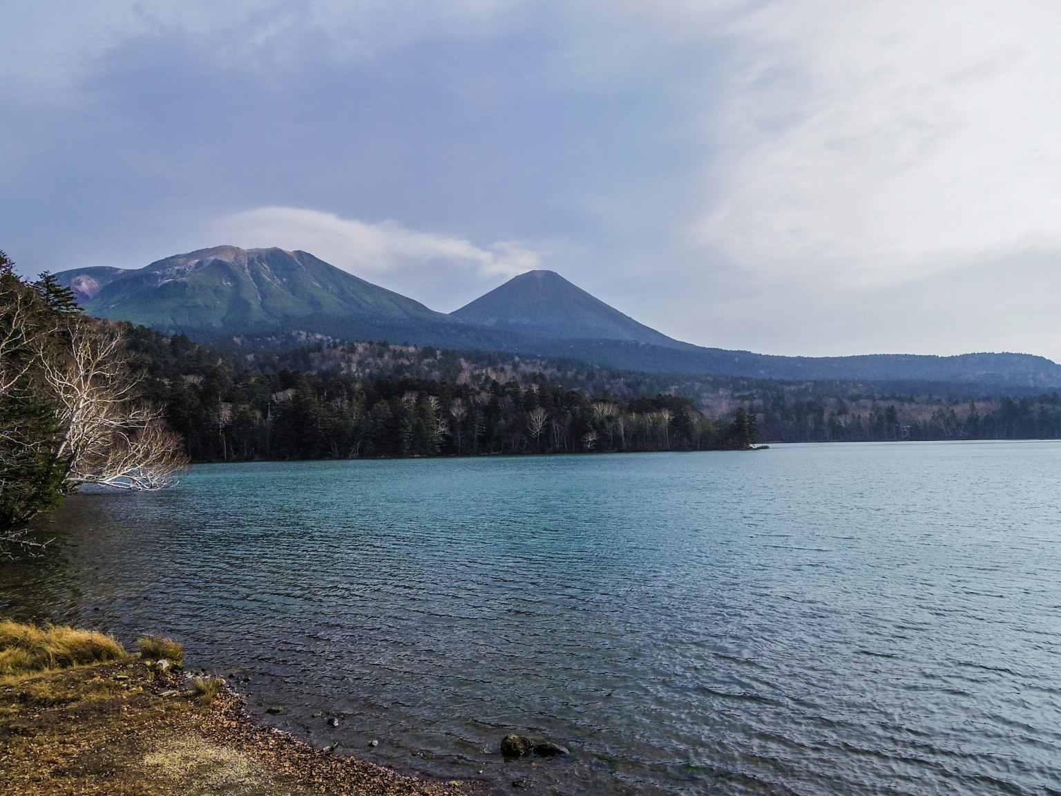 Malersicher Blick auf einen See und Berge ruhiges blaues Wasser und ruhiger Himmel