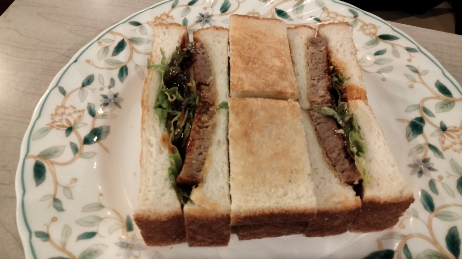 Panino fatto con pane bianco tostato farcito con carne e verdure