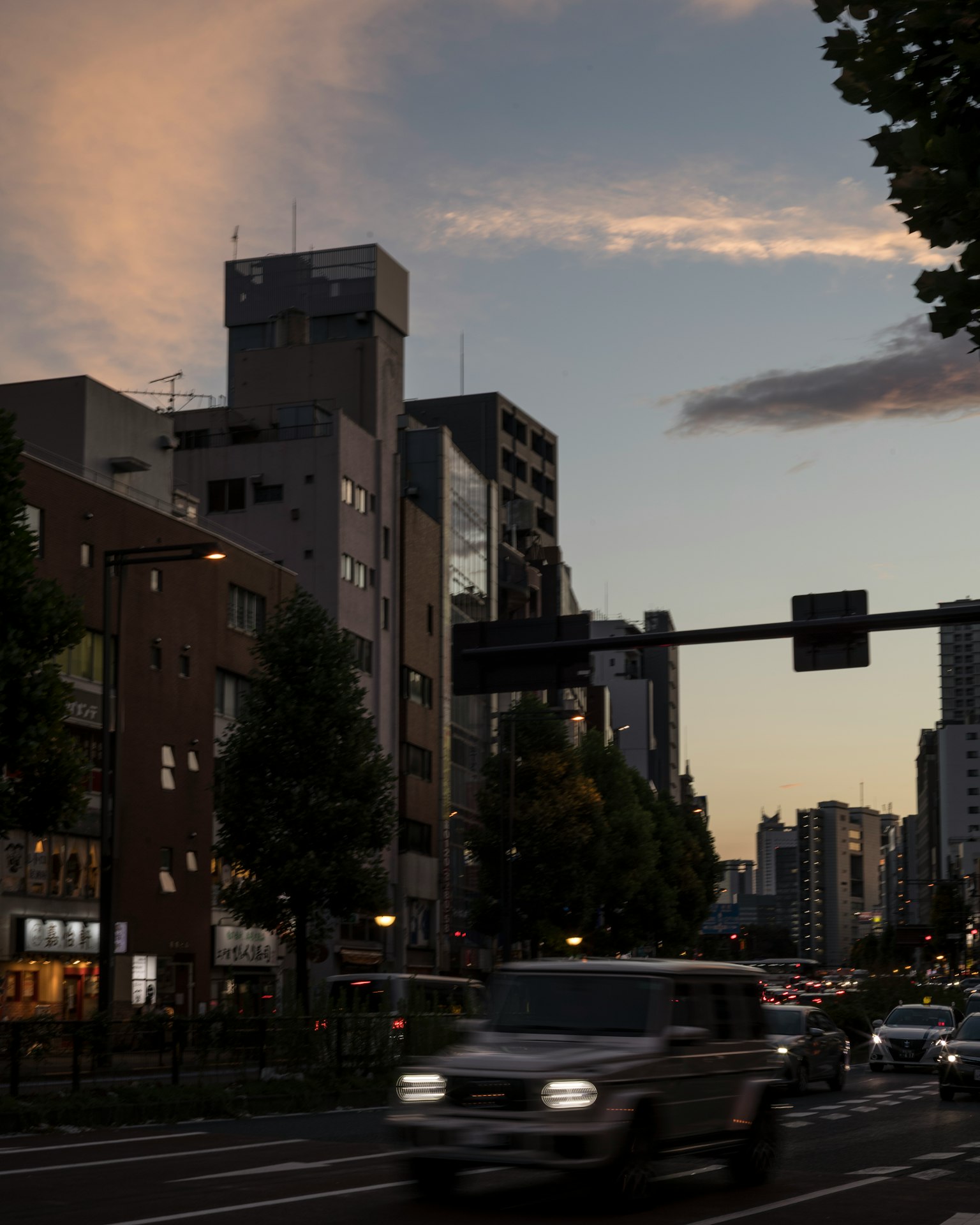 夕暮れ時の都市風景 車が通る街道と高層ビル