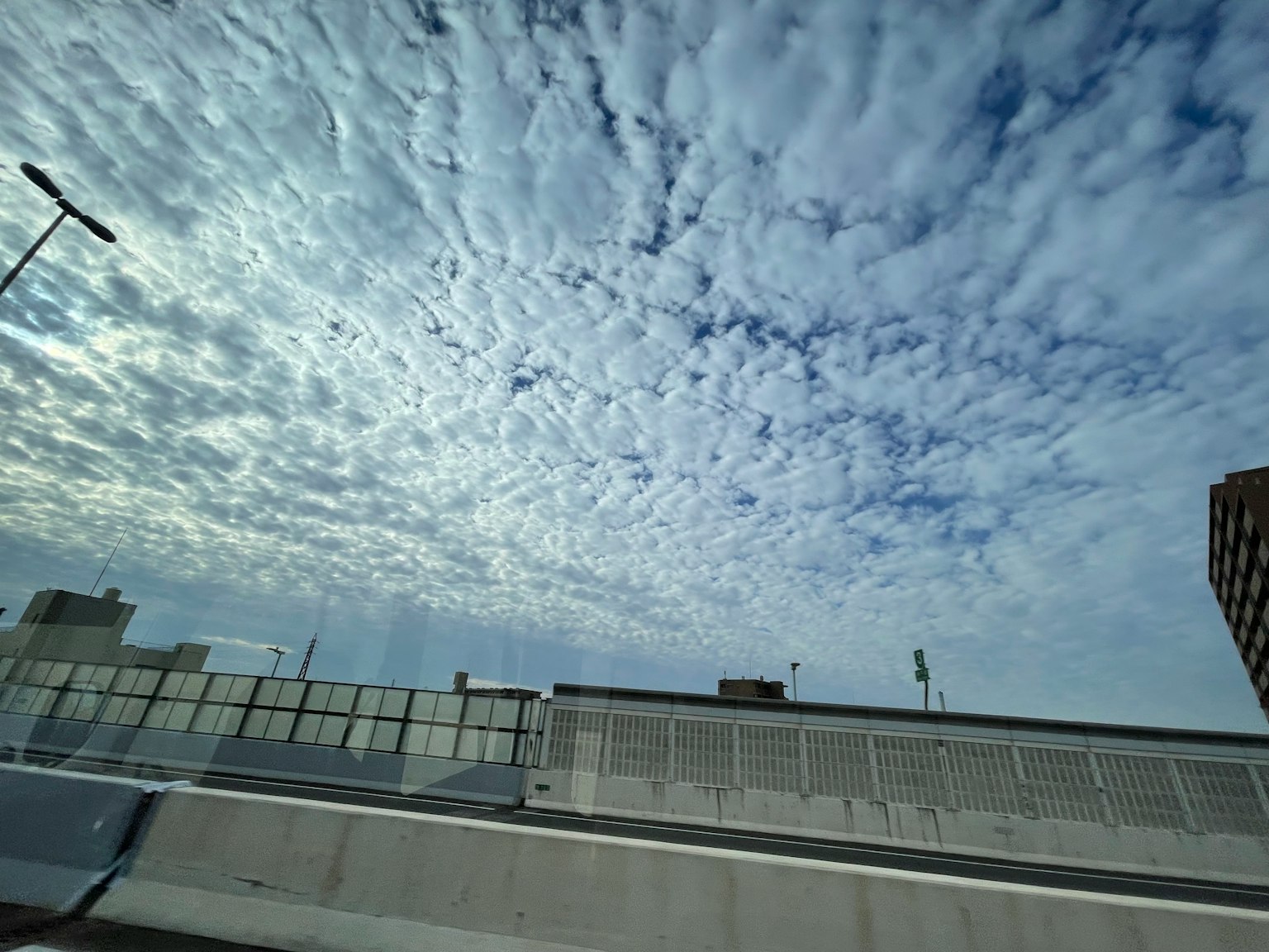 Cielo blu con modelli di nuvole e un accenno a strutture urbane