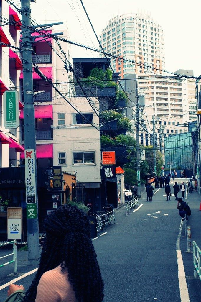 高層ビルに囲まれた街路の電線と看板のある風景