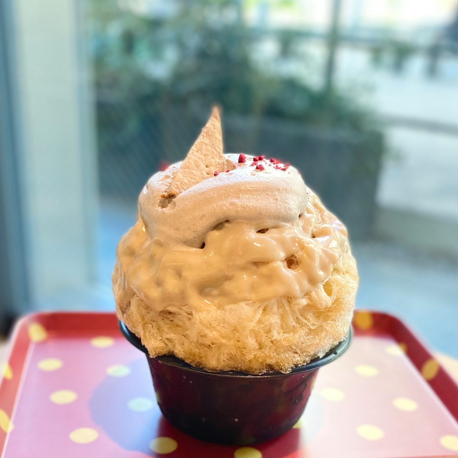 Copa de helado cubierta con crema y chispas rojas