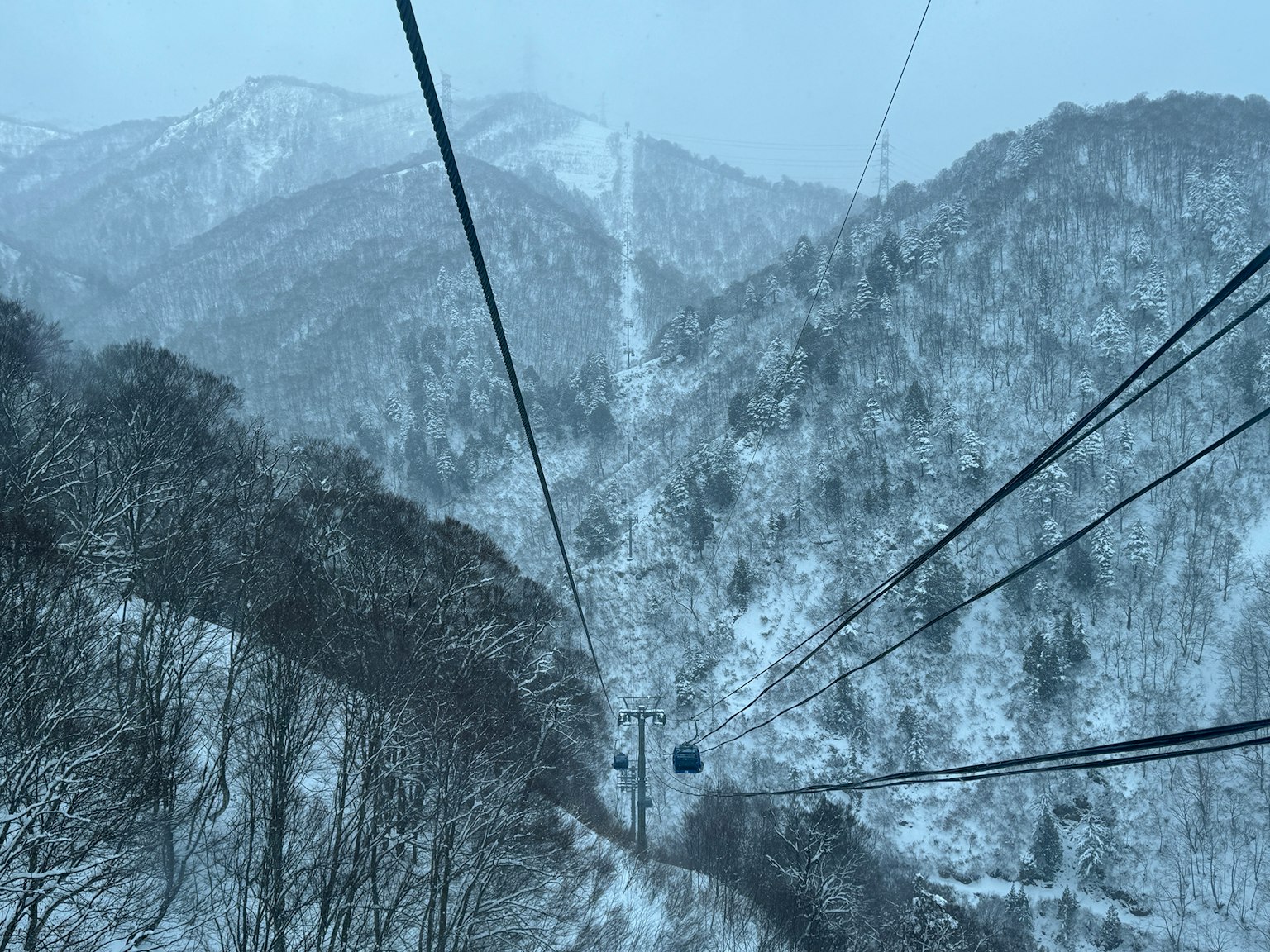 눈 덮인 산과 케이블카 선로