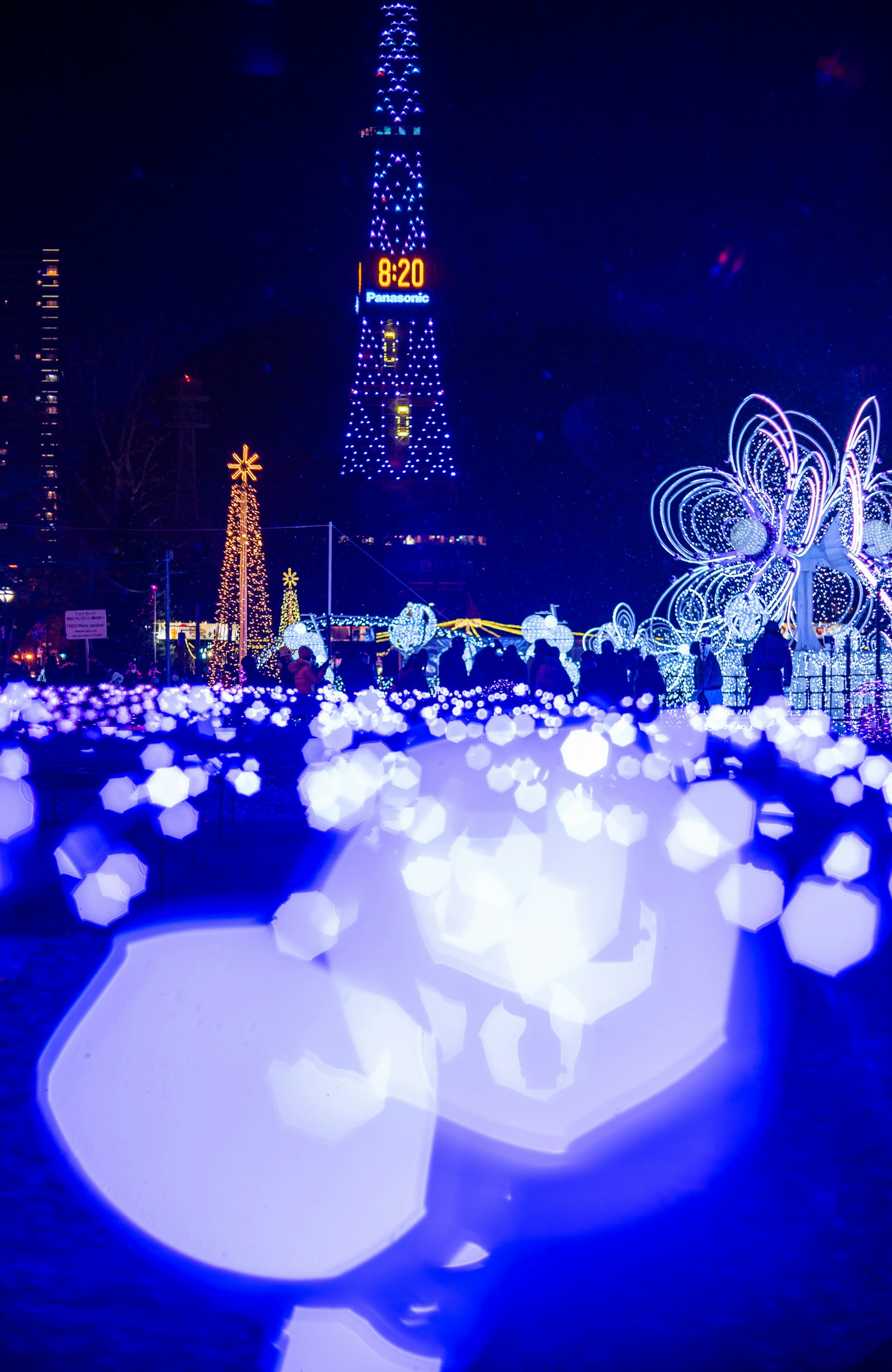 Scenario notturno con sfere blu luminose e Torre Eiffel illuminata