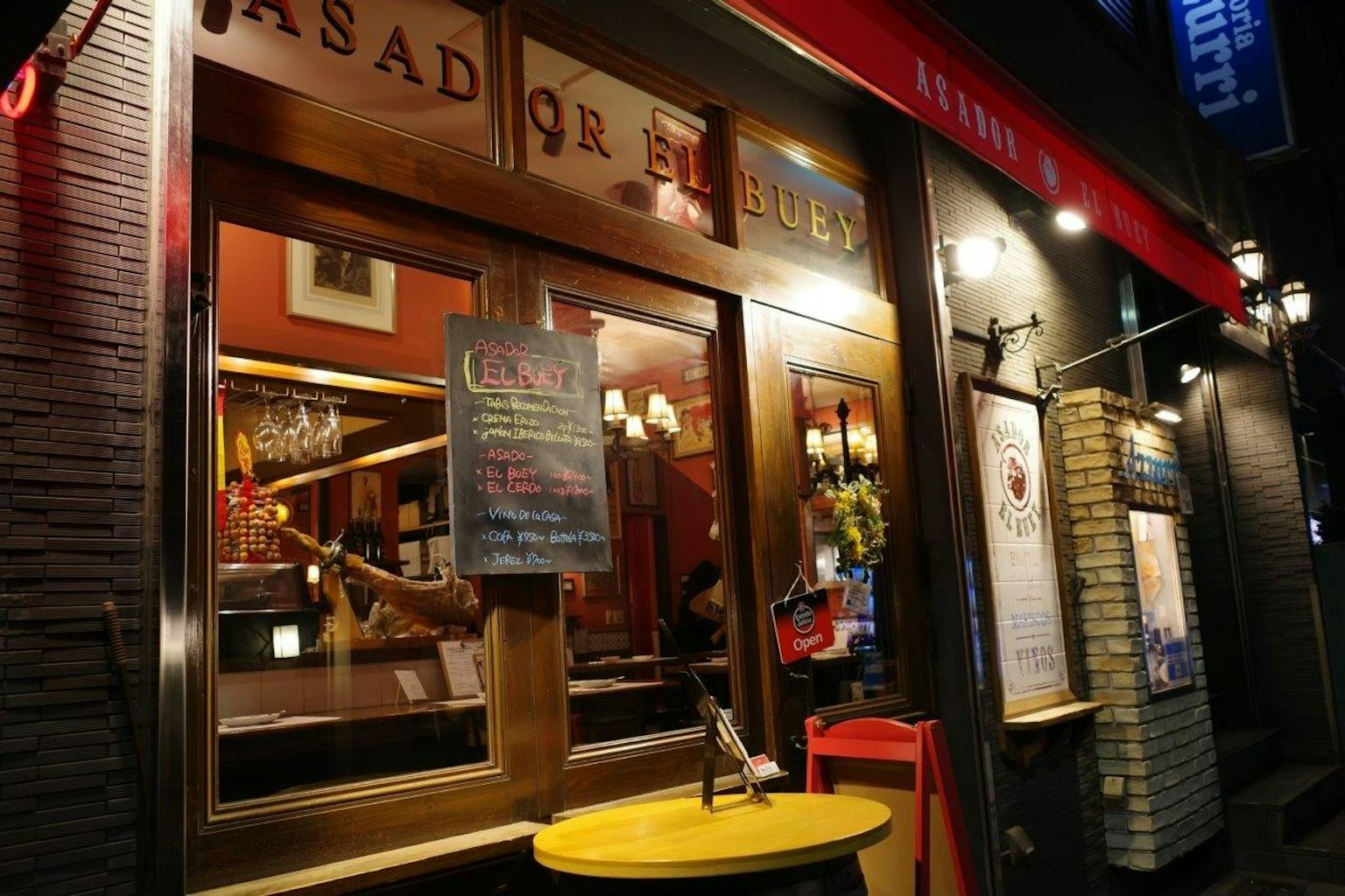 Extérieur d'un bar avec un éclairage chaleureux et une signalisation colorée