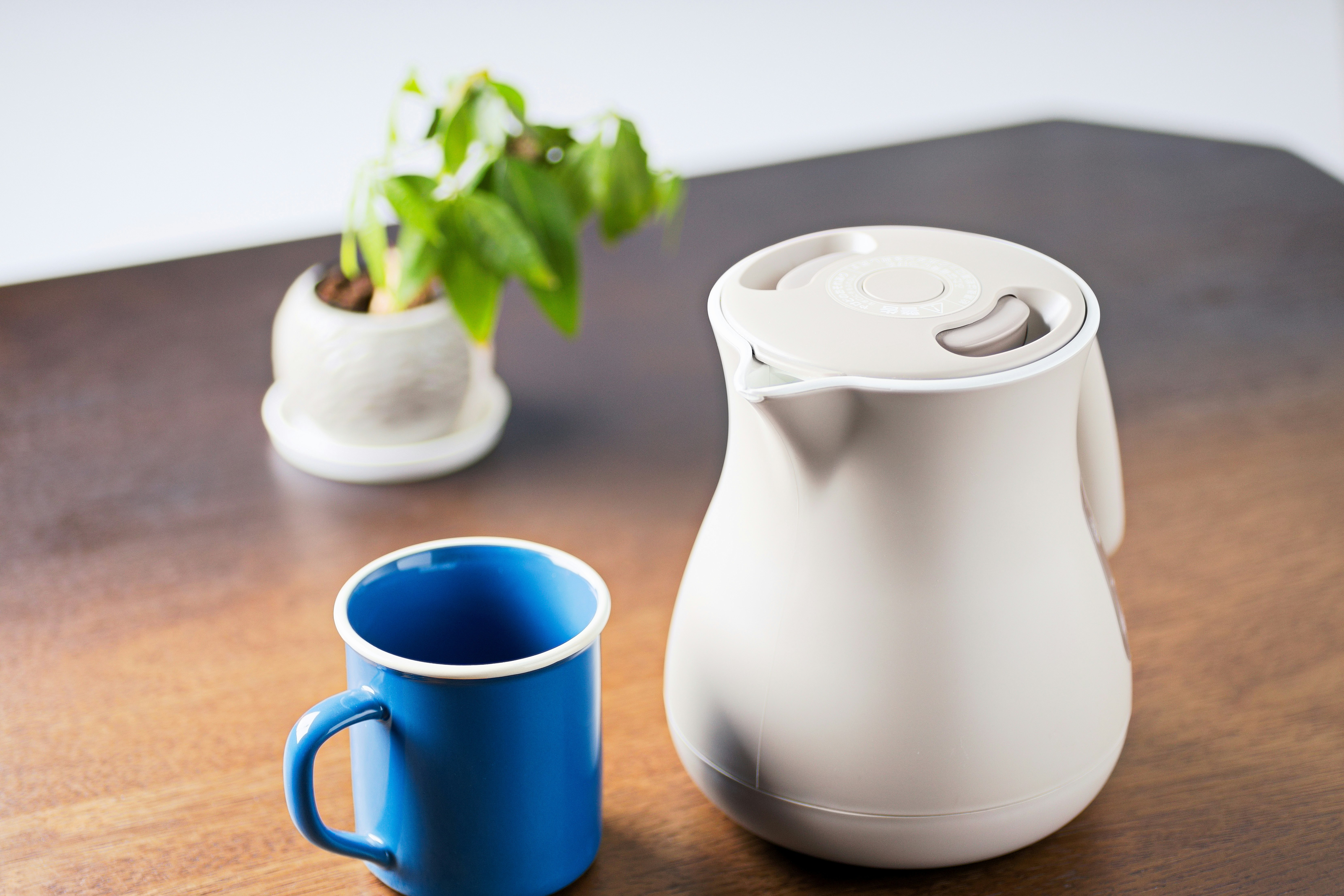 朝の光の差すテーブルでマグカップとケトル
