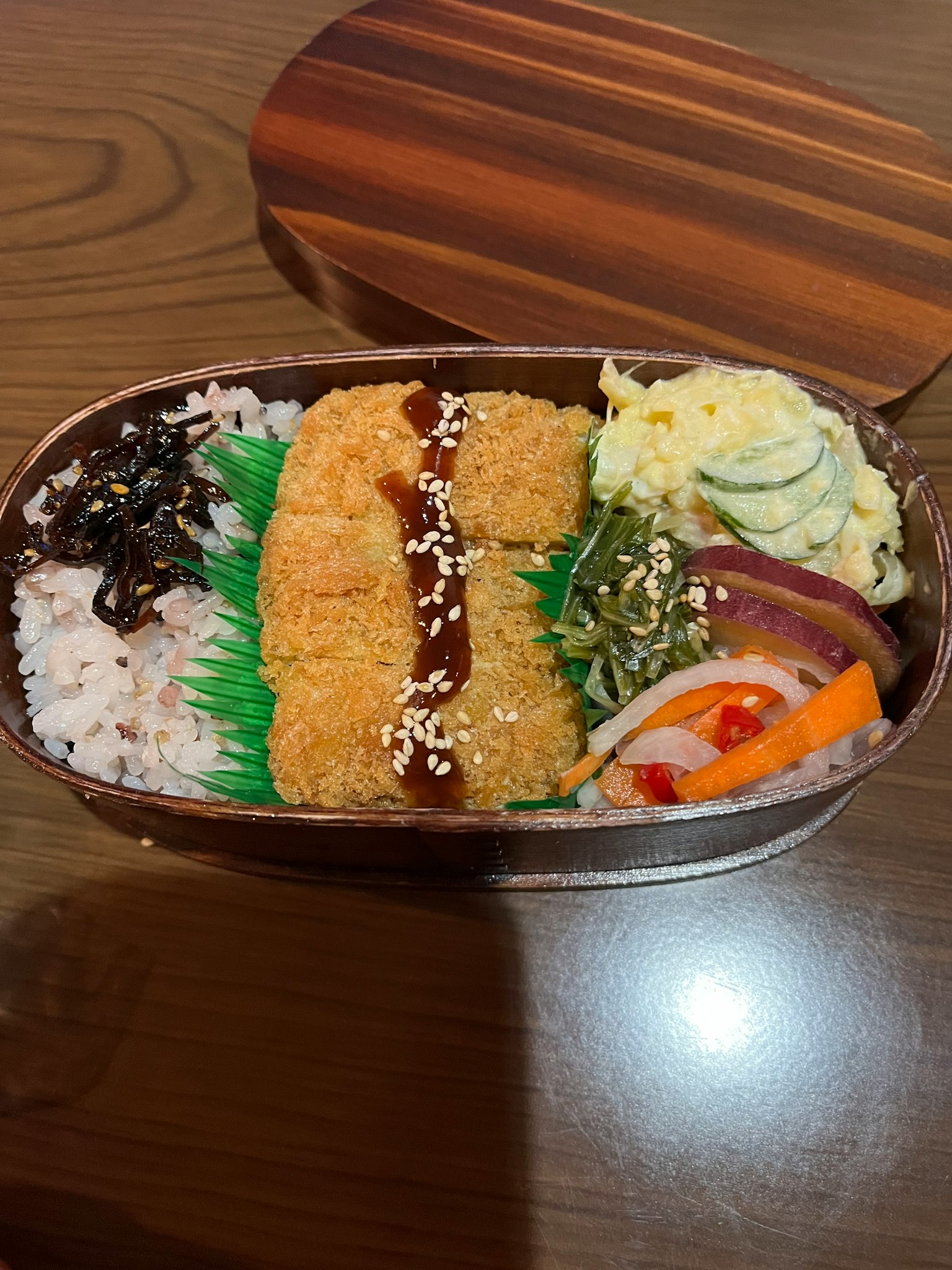 Hình ảnh hộp bento chứa cơm, gà rán, salad rau và tamagoyaki