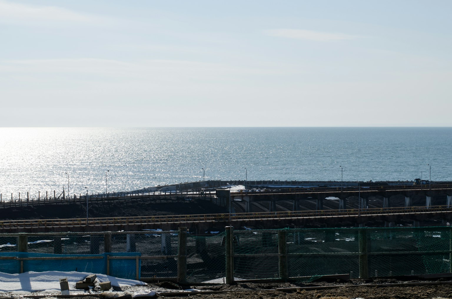 Vista panoramica dell'oceano blu e del cielo con un molo in costruzione visibile