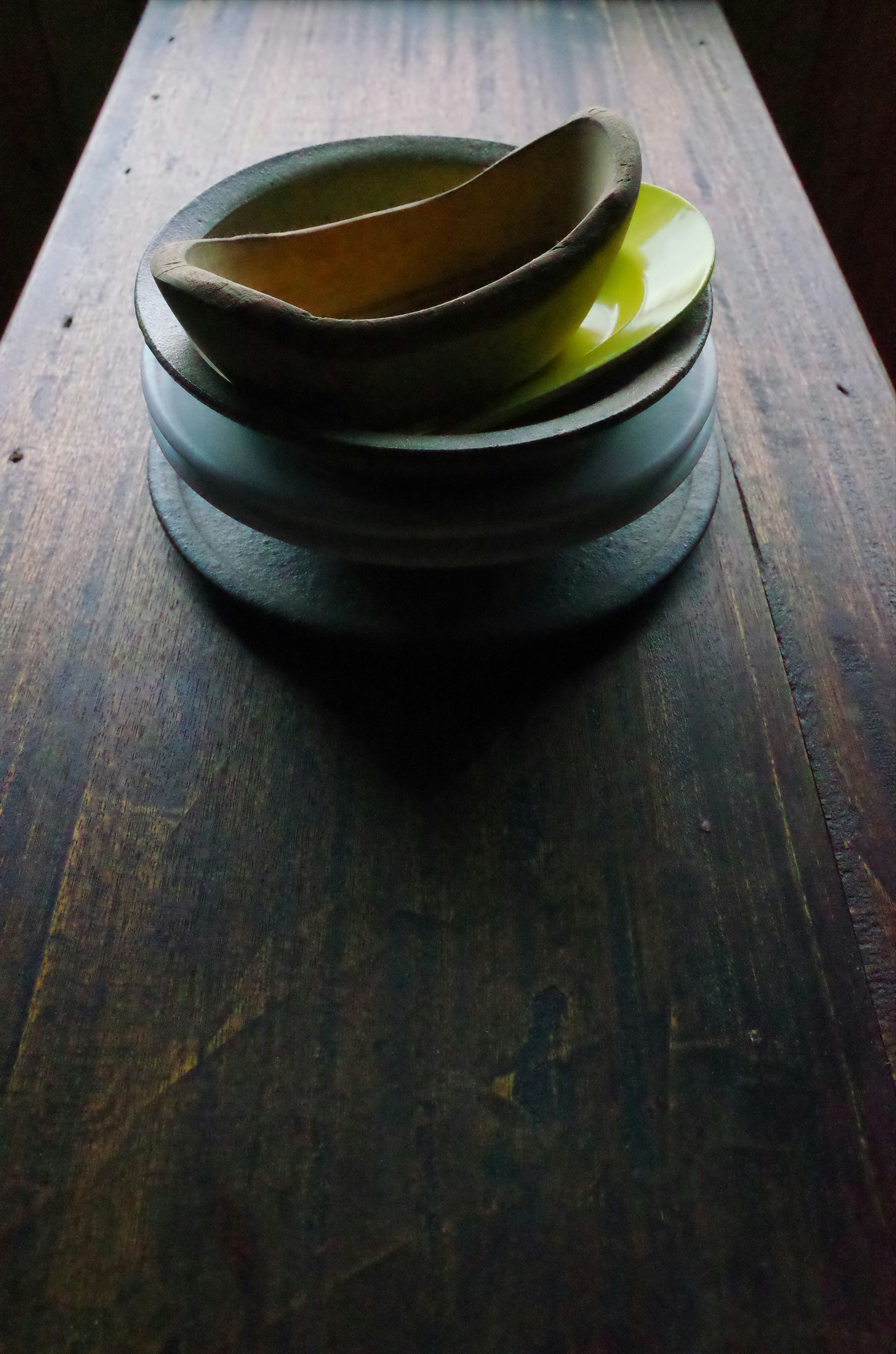 木のテーブル上の茶器と湯気のあるカップ