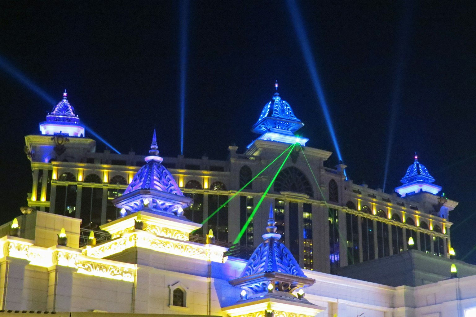 หลังคาอาคารที่มีแสงสีน้ำเงินและลำแสงเลเซอร์ในเวลากลางคืน