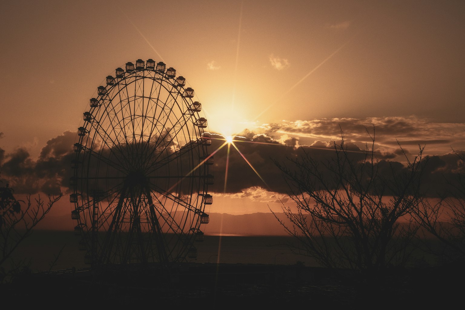 Silhouette di una ruota panoramica al tramonto