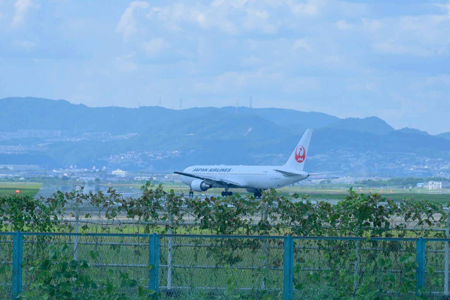 飛機在跑道上滑行，背景是山脈