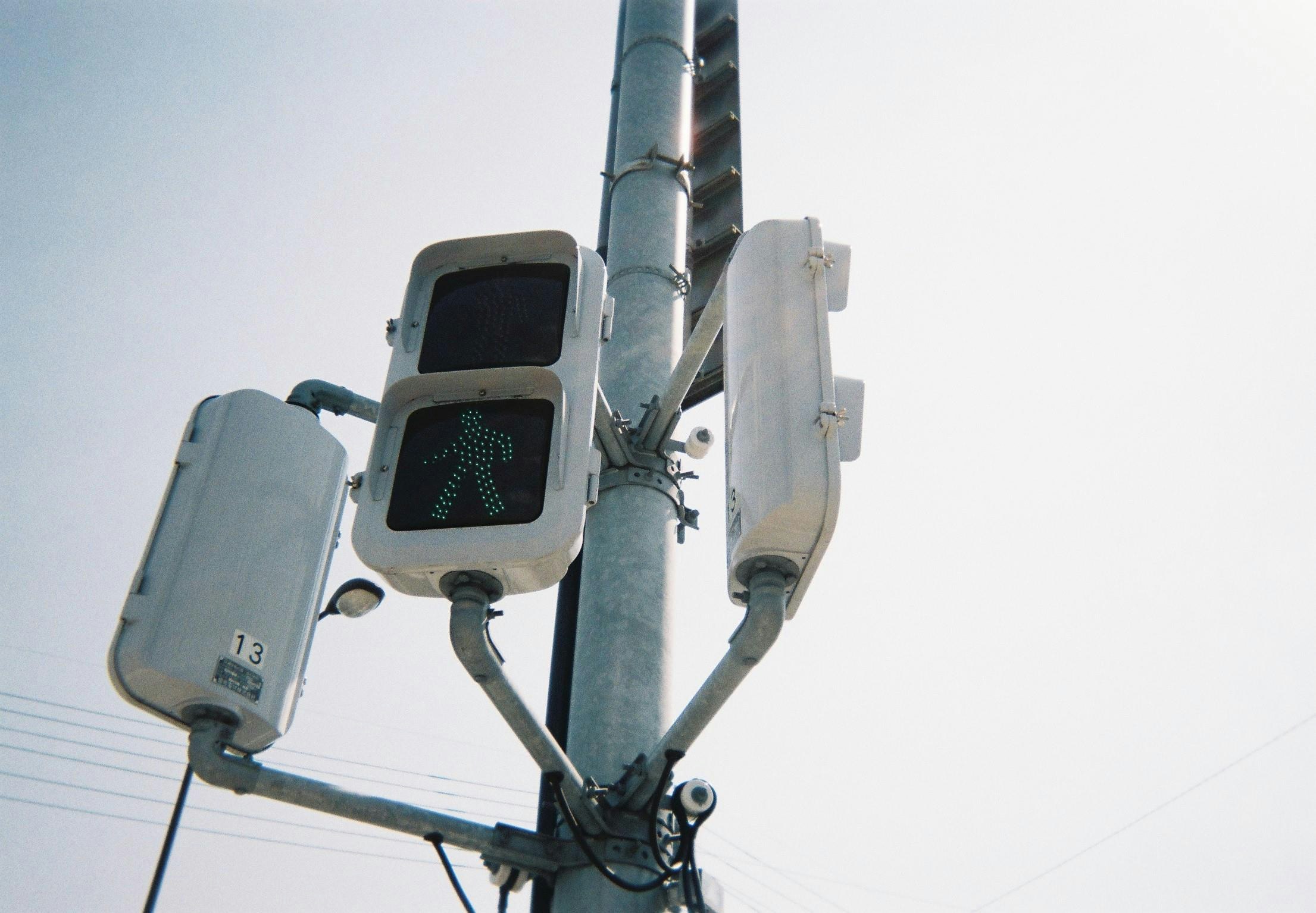 upper view of a pedestrian traffic signal with a three-way signal head
