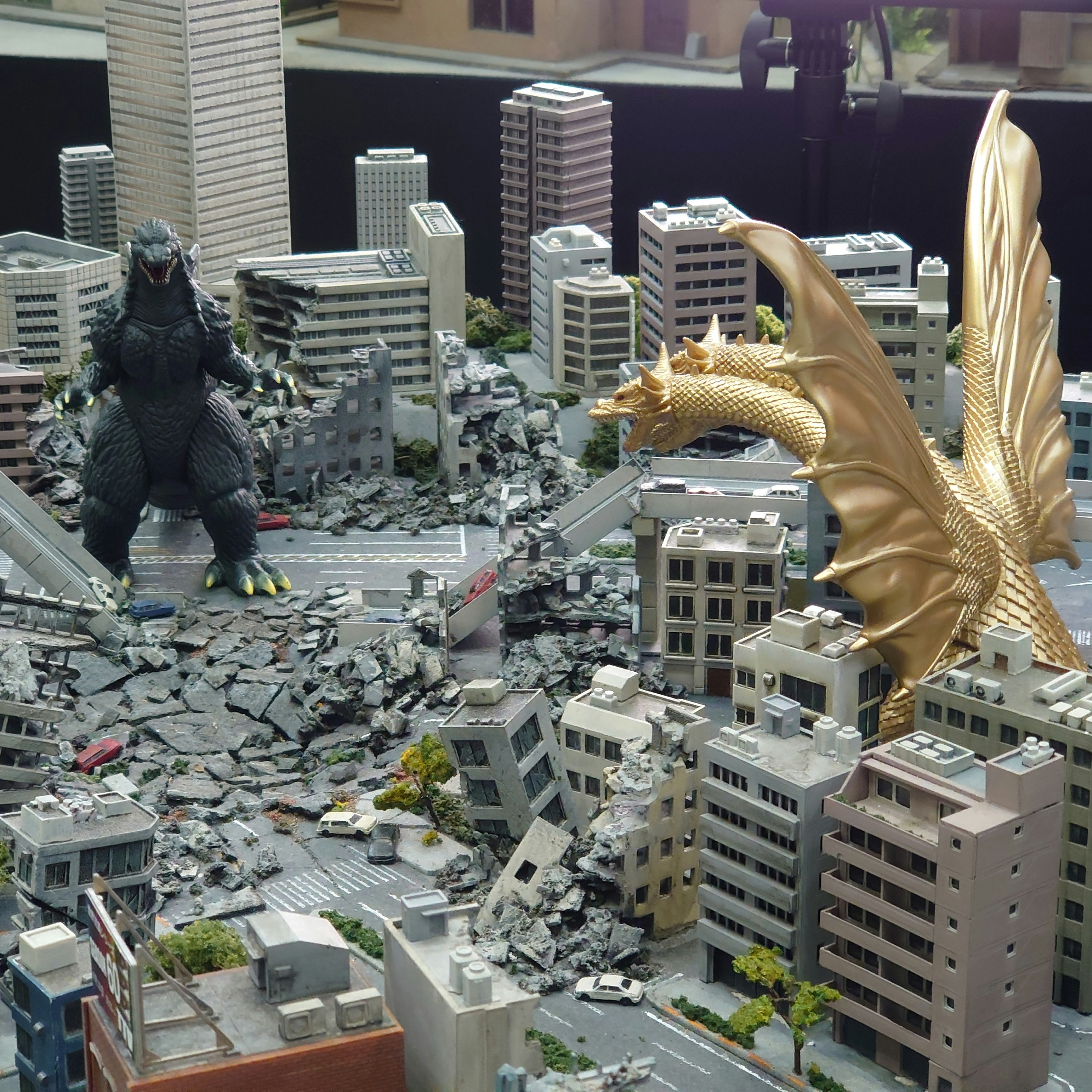 A ruined cityscape with a giant golden monster figure