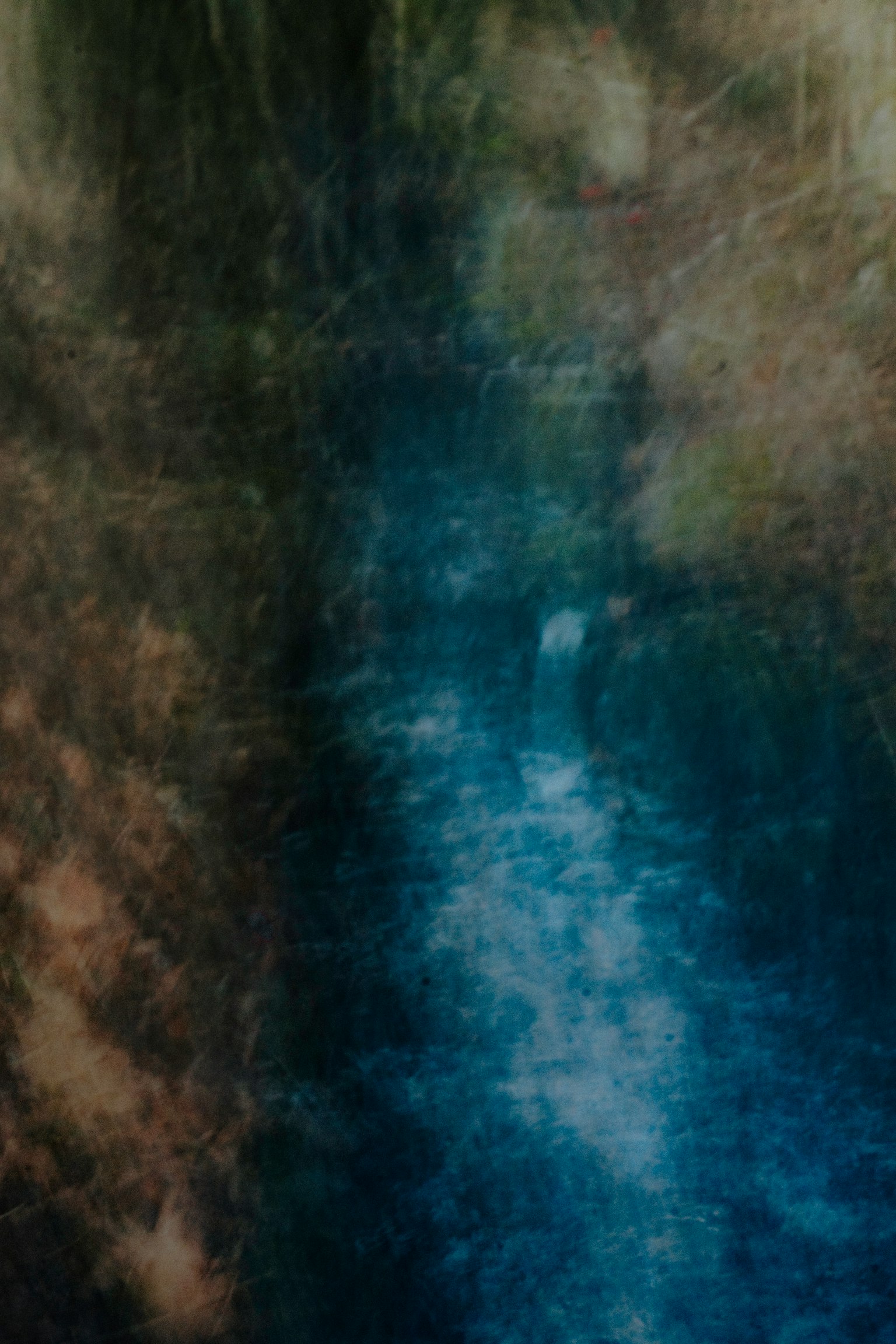 Eine verschwommene Naturszene mit blauem Wasserfluss und sanftem Hintergrund