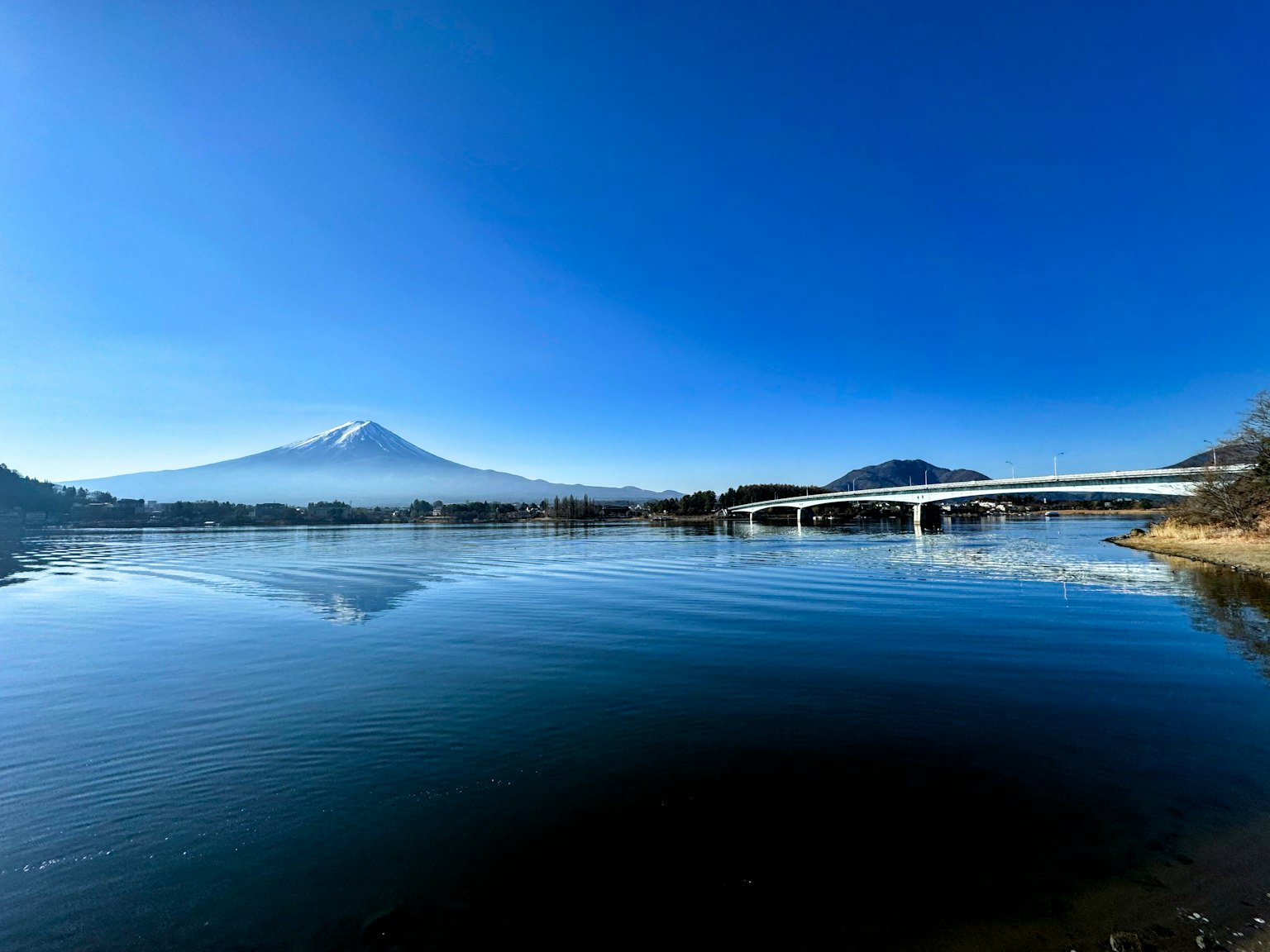 Vista escénica del monte Fuji reflejándose en el lago bajo un cielo azul claro