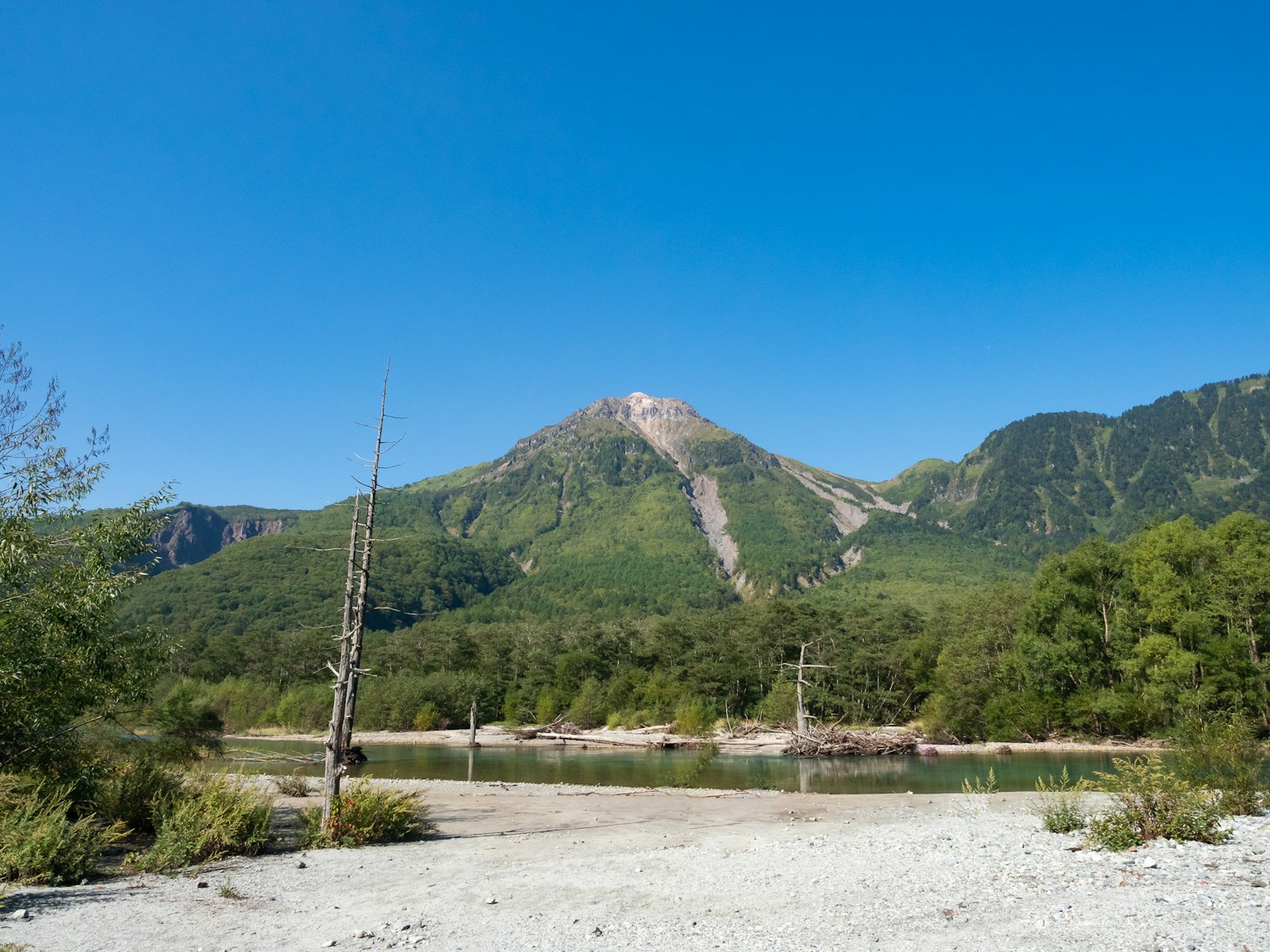 Berglandschaft mit einem Fluss unter einem klaren blauen Himmel