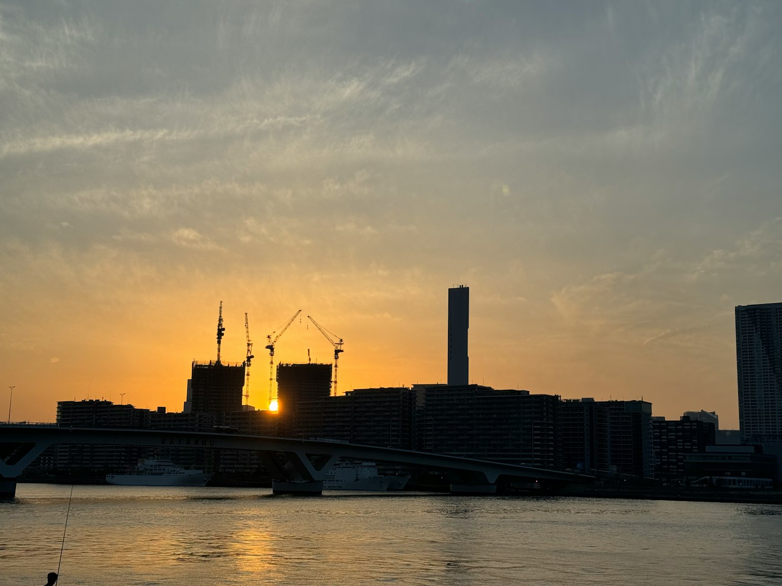 日落时分城市轮廓与建筑起重机