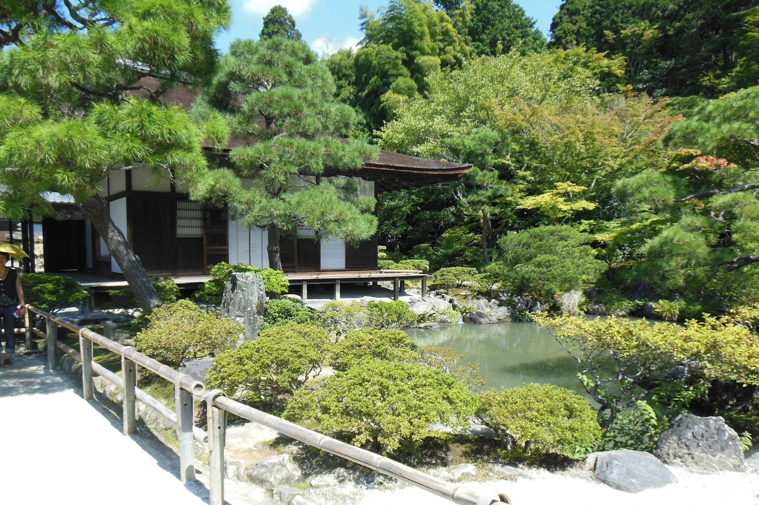 风景如画的日本花园，拥有传统建筑和郁郁葱葱的绿树
