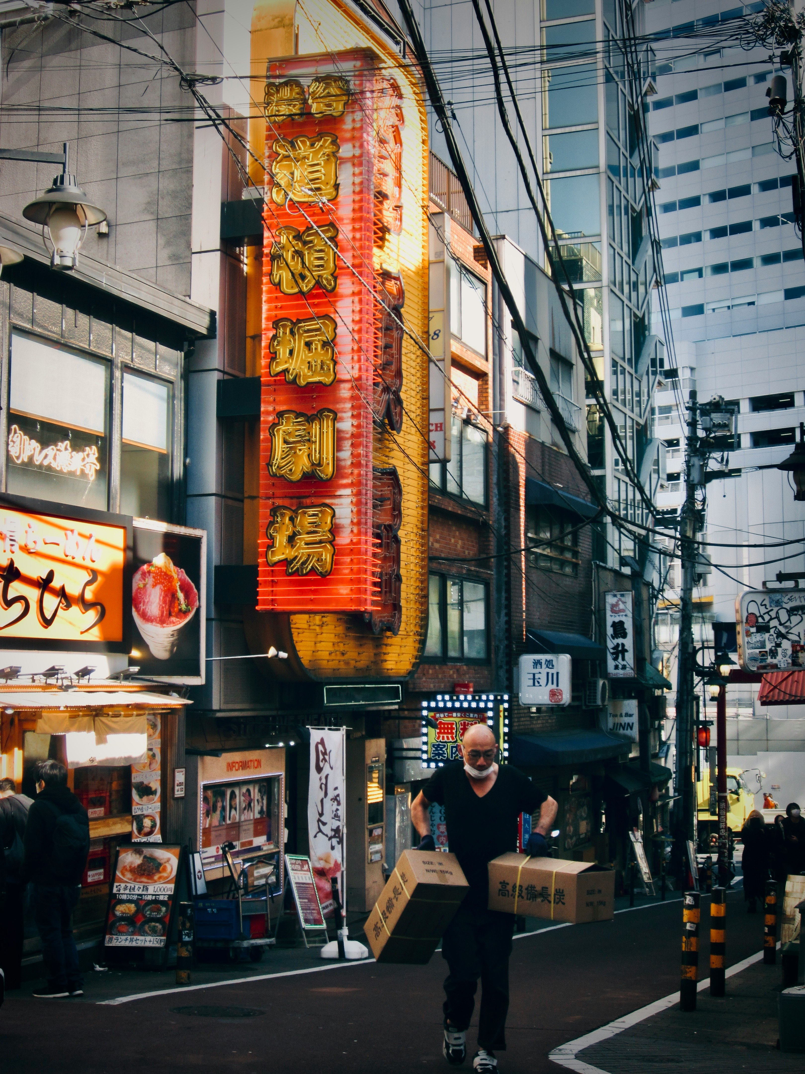 赤い提灯が並ぶ狭い路地の商店街の軒先