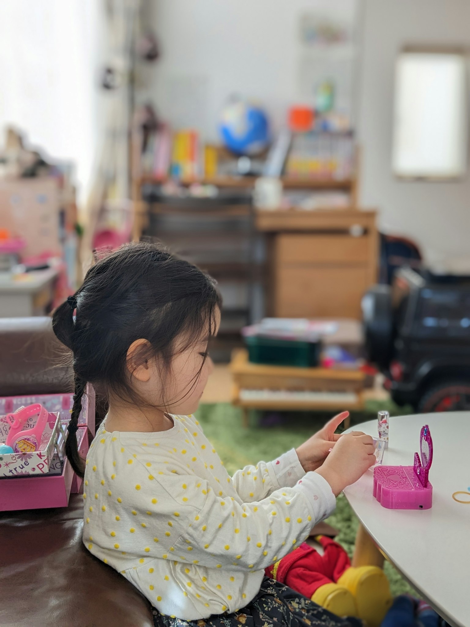 A child playing at a table with toys and furniture in the background