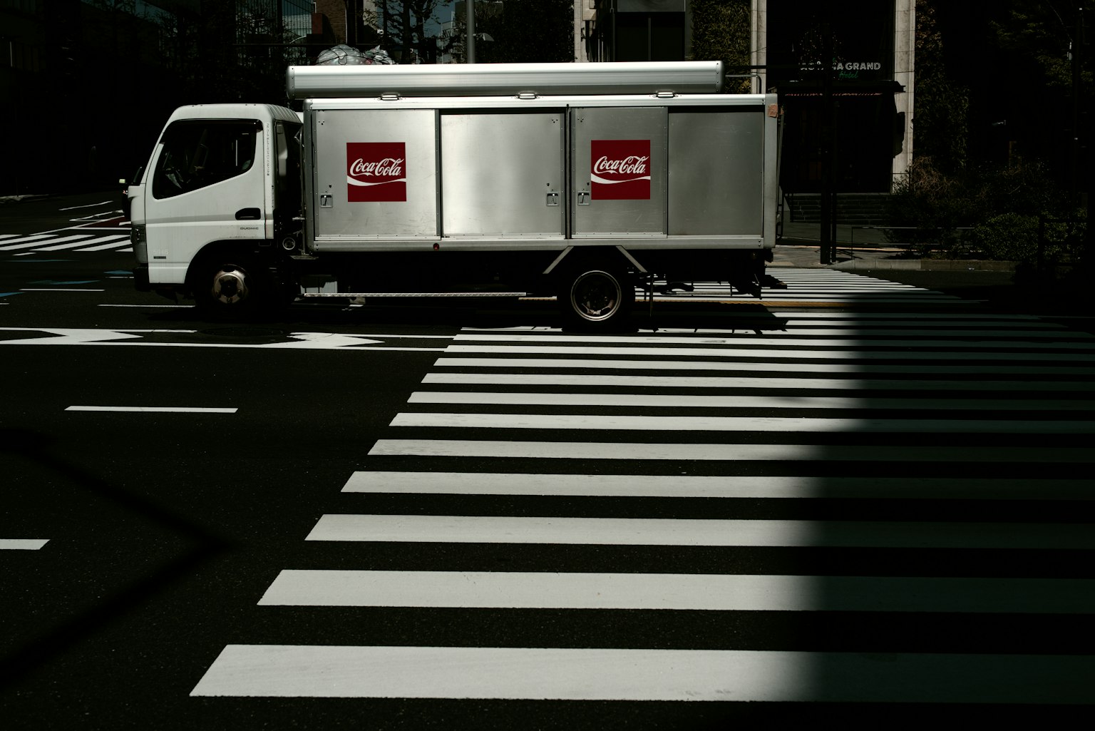 รถบรรทุกสีเงินข้ามทางม้าลายสีขาว