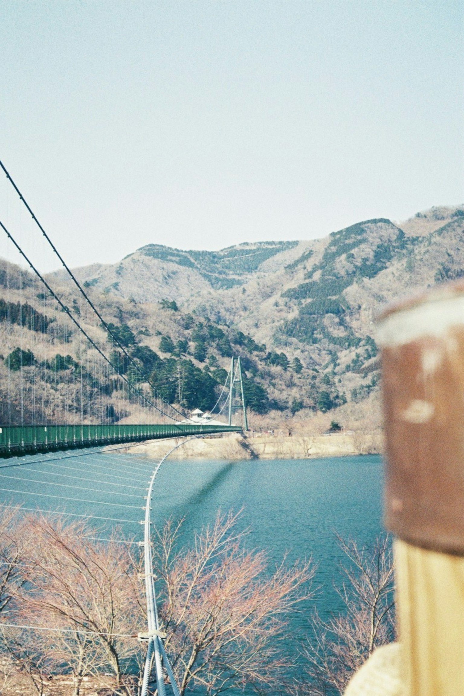 Vista panoramica di un ponte sospeso su un lago con montagne sullo sfondo