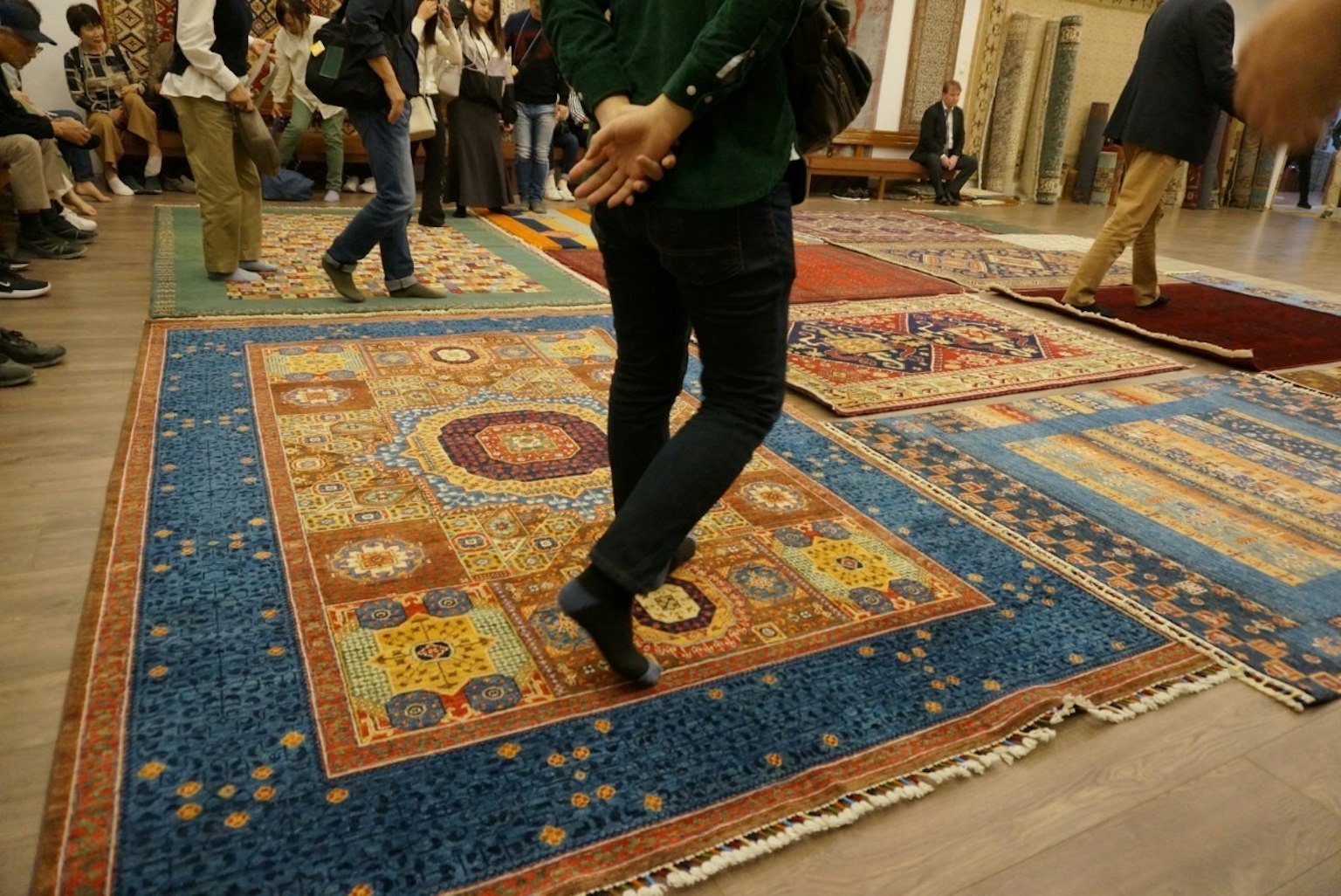 Visiteurs marchant sur des tapis colorés dans un cadre d'exposition