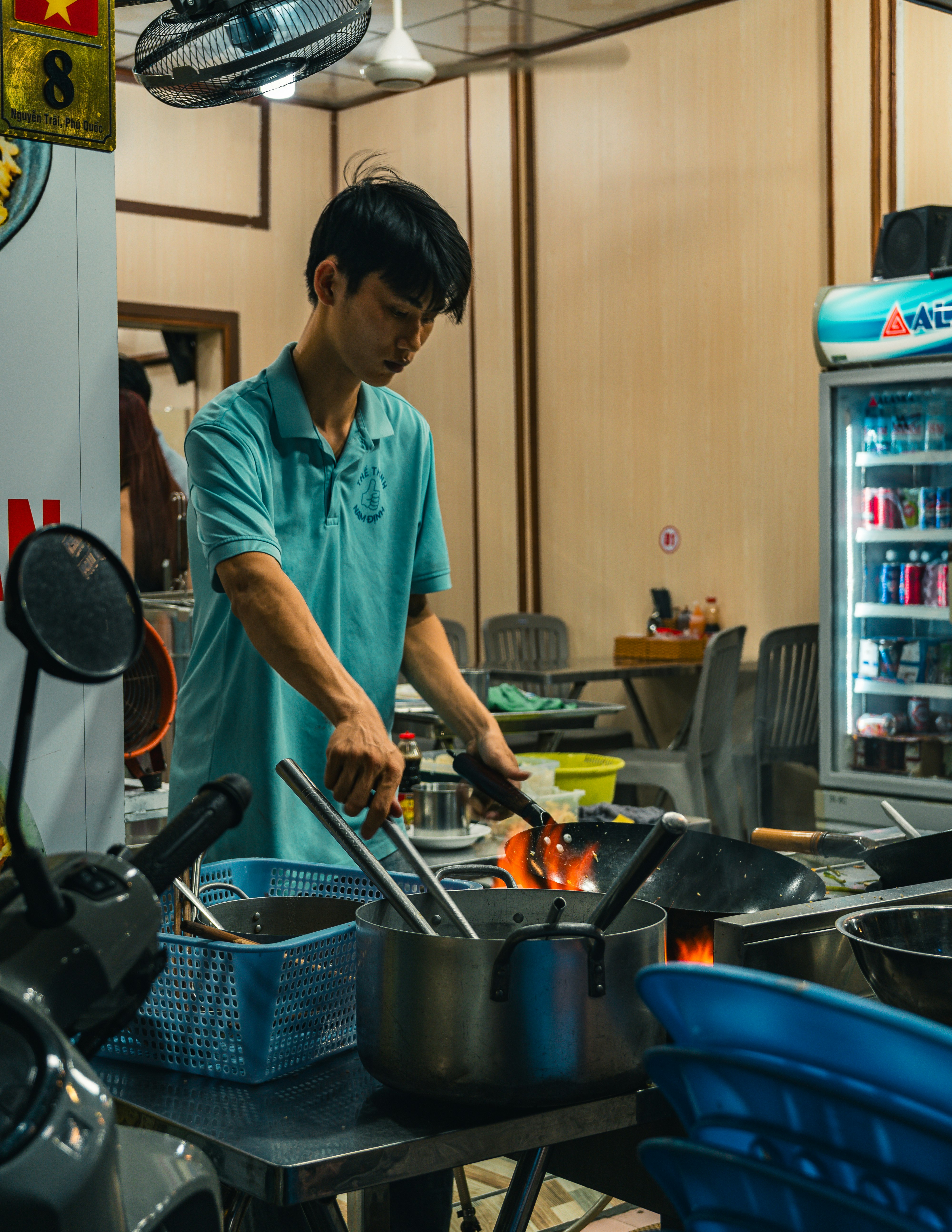 廚房裡在爐灶旁操作廚具的廚師