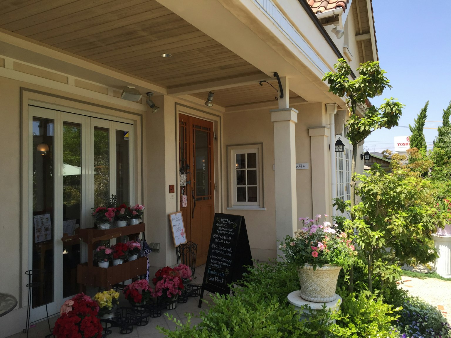 Extérieur d'un café charmant entouré de fleurs et de verdure