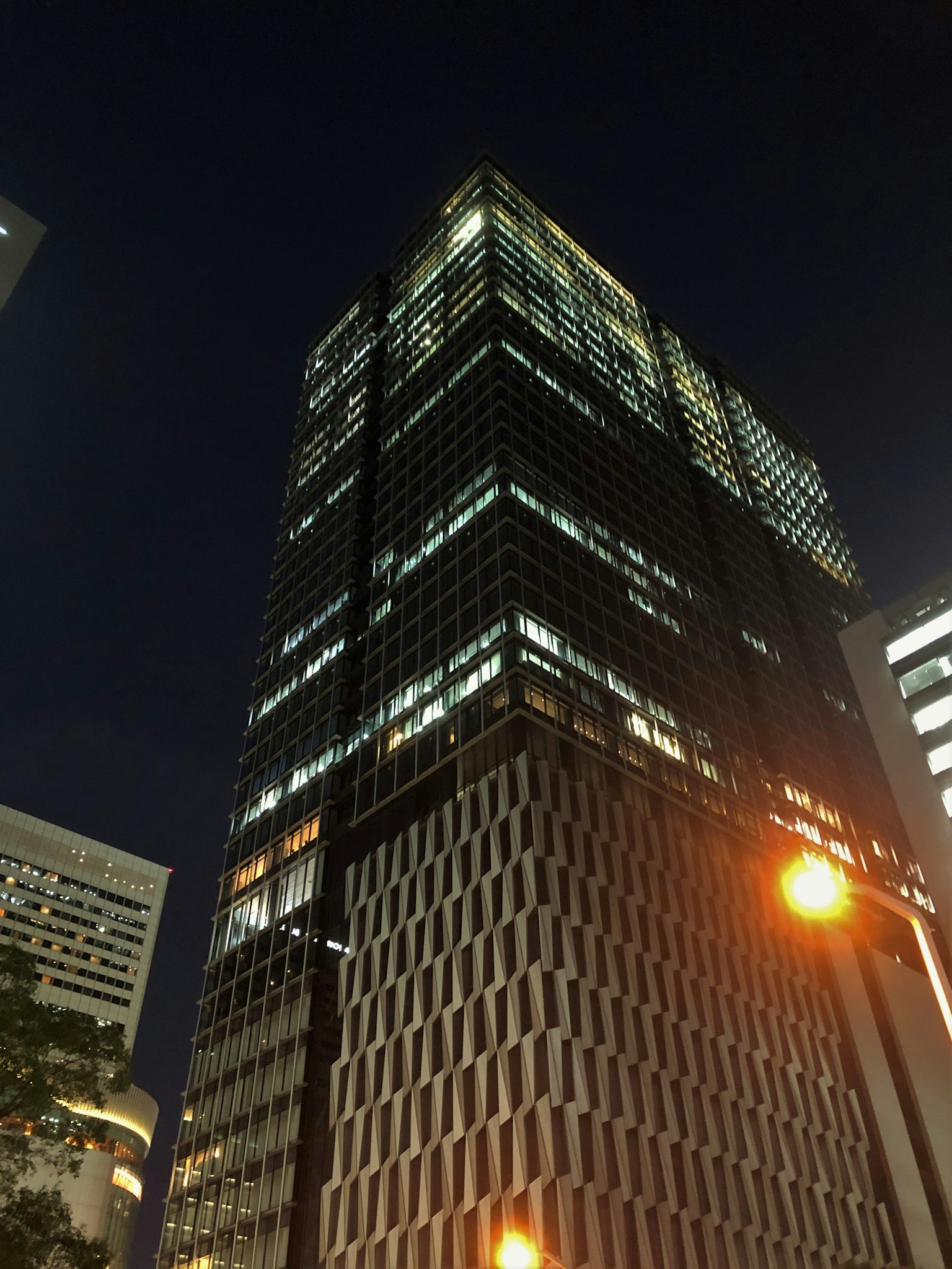 Tòa nhà chọc trời hiện đại vươn lên trong cảnh quan đô thị vào ban đêm