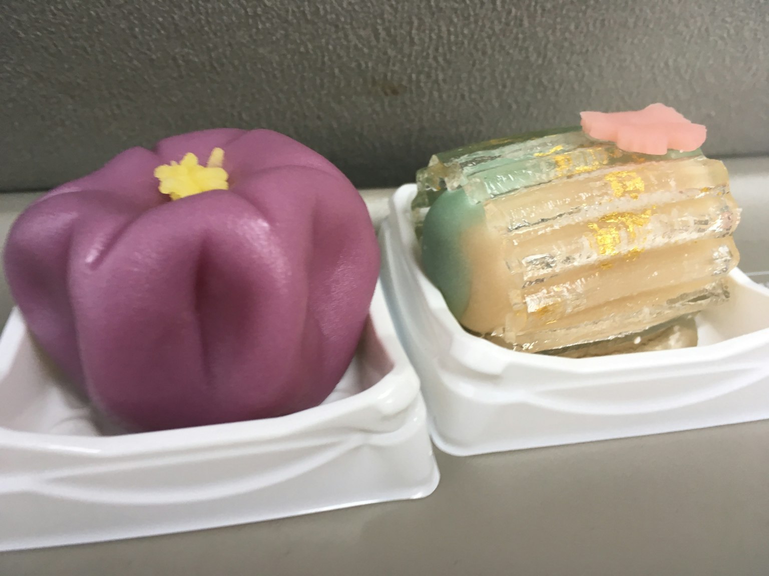 紫色形狀的和菓子和透明層狀的和菓子在白色容器中