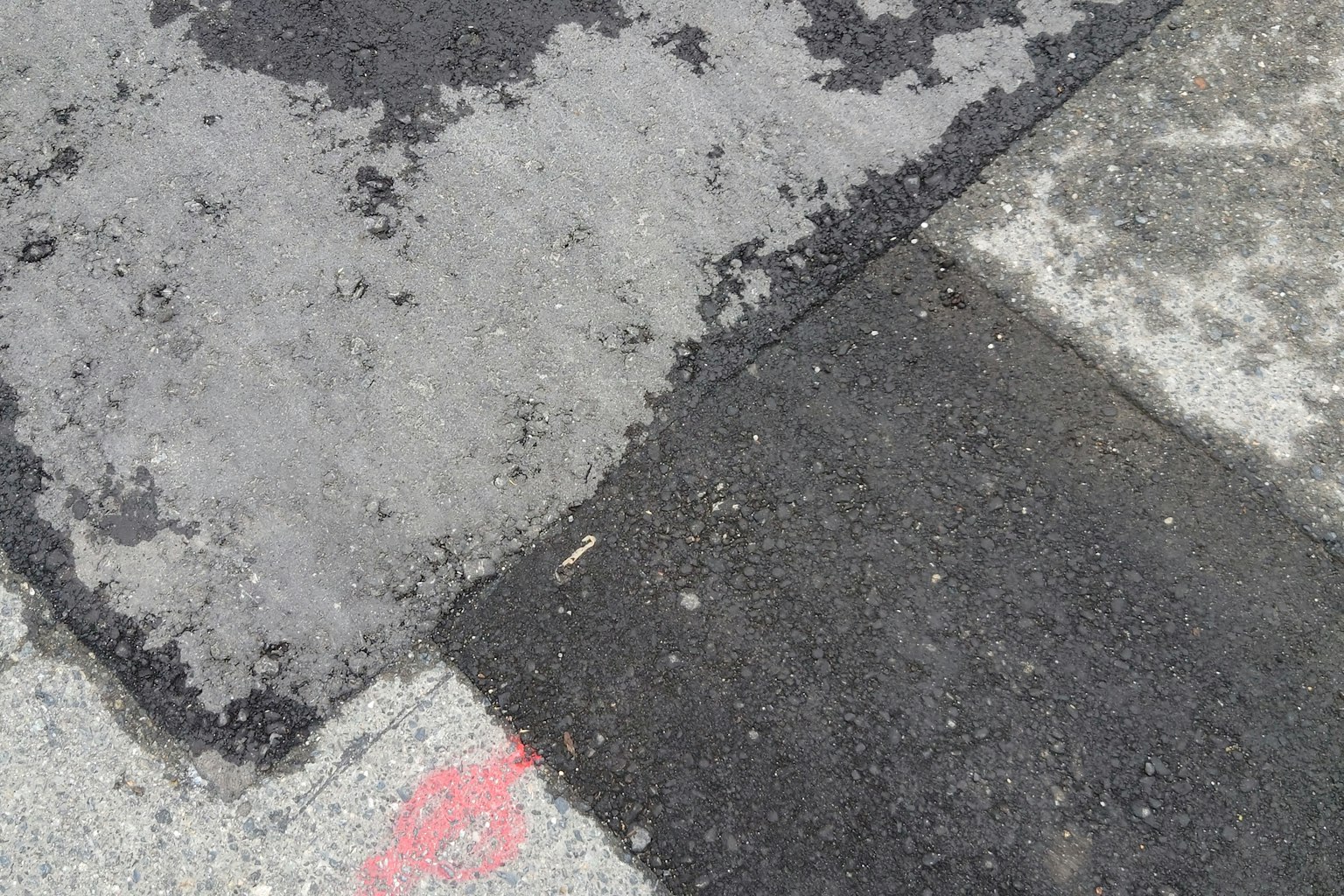 Tekstur dari bagian-bagian berbeda dari jalan yang dipaving saling bersilangan