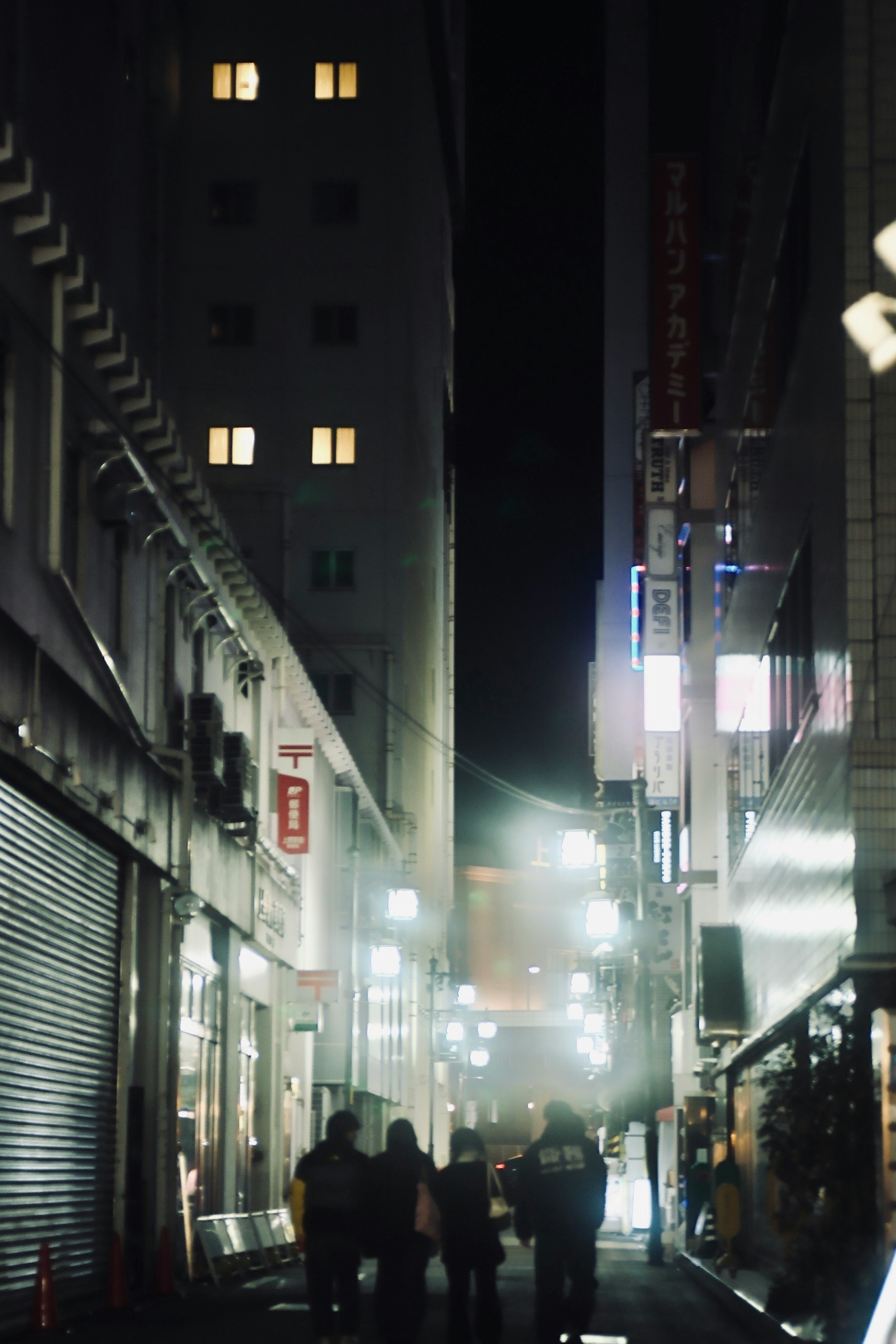 夜の路地に並ぶシャッターと街灯の光