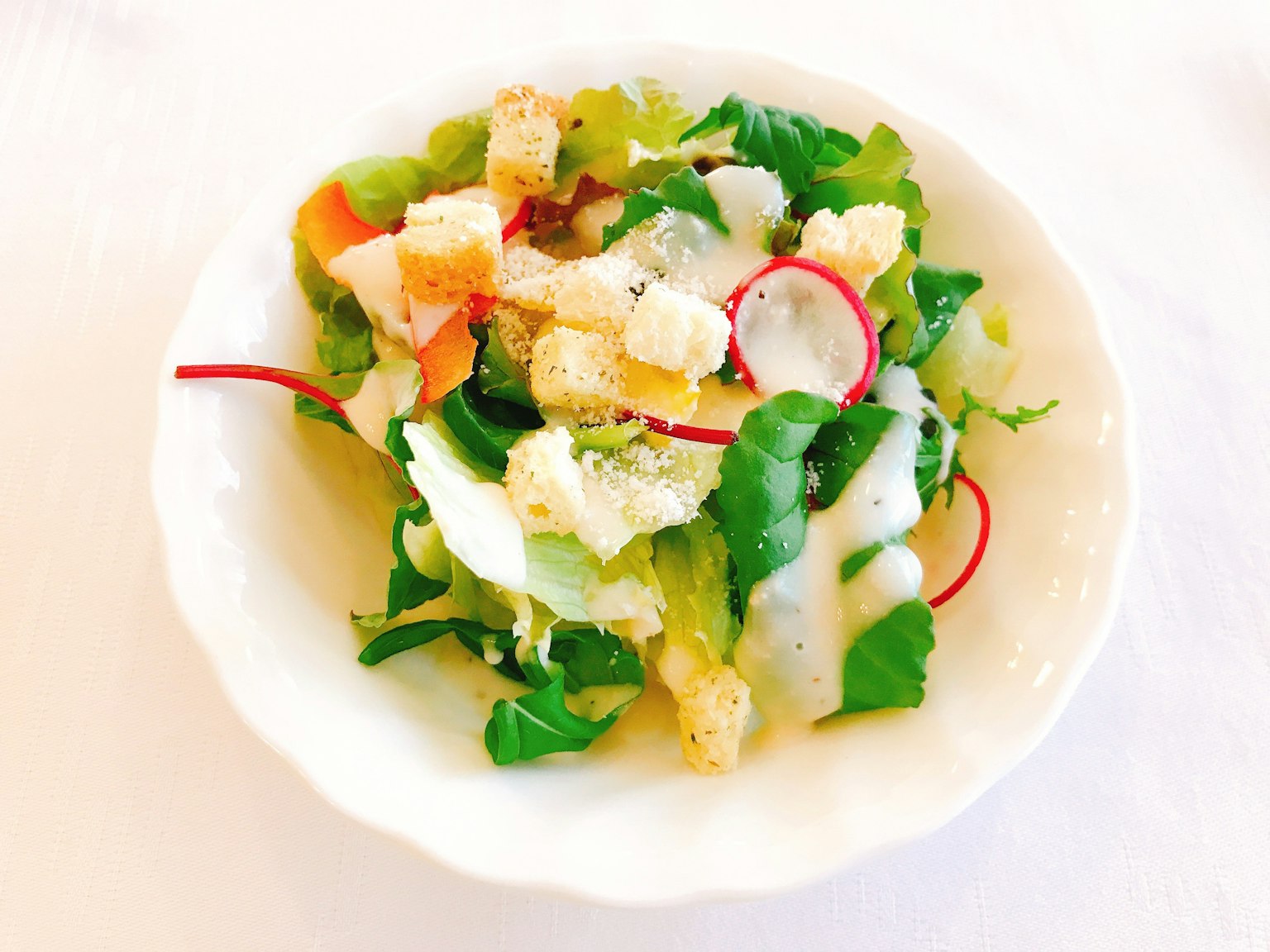 Salade fraîche avec de la laitue, des radis, des croûtons et une sauce crémeuse