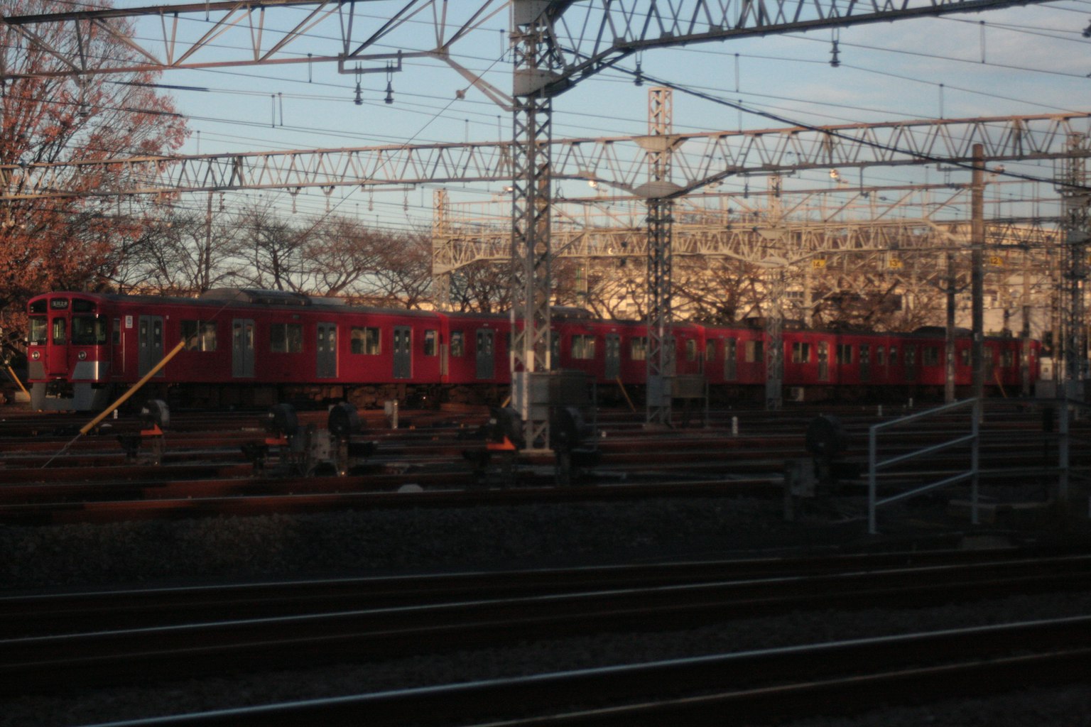 Red train parked on tracks in a railway yard