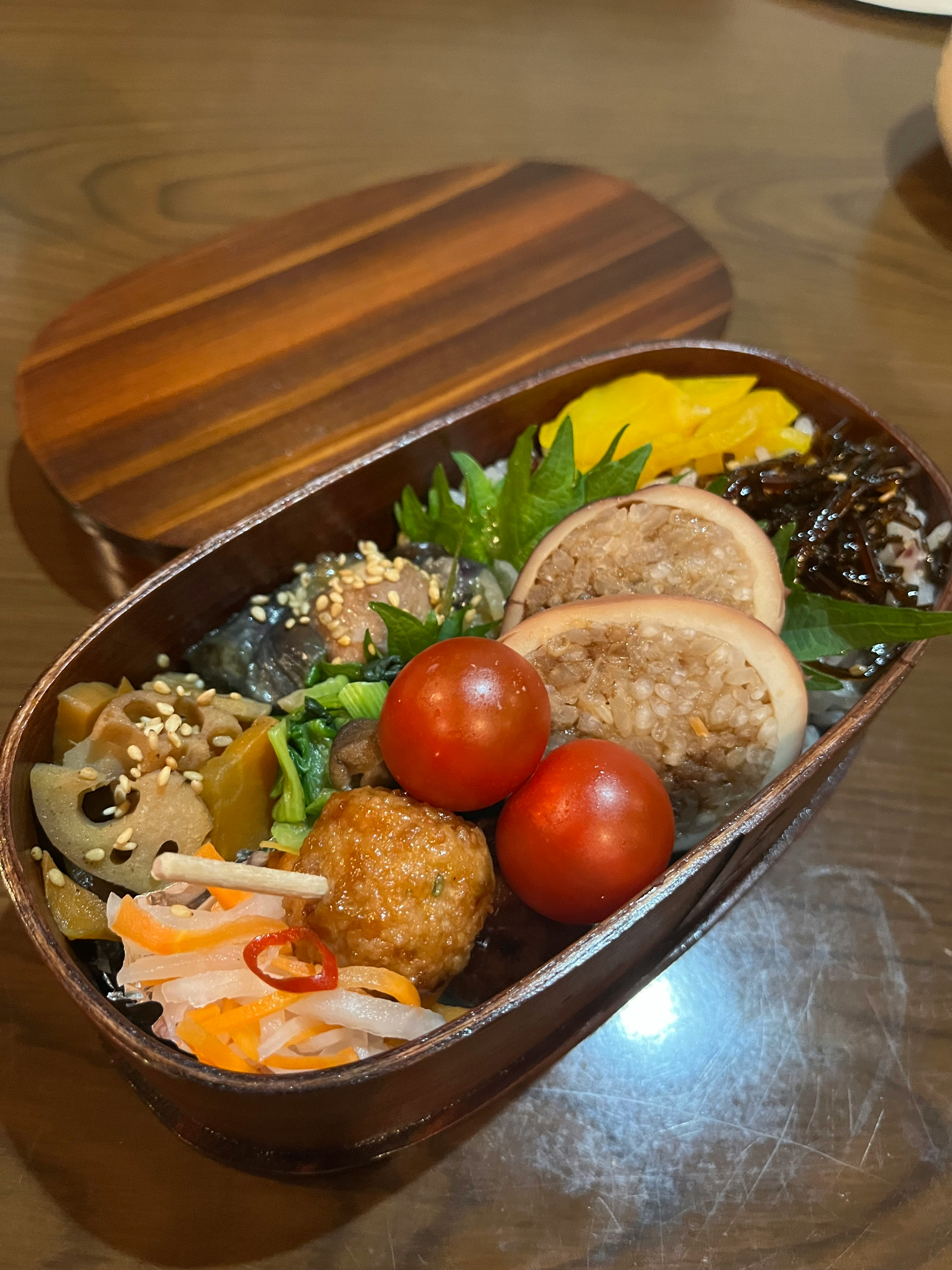 美しい和風弁当箱に色とりどりの食材が盛り付けられている