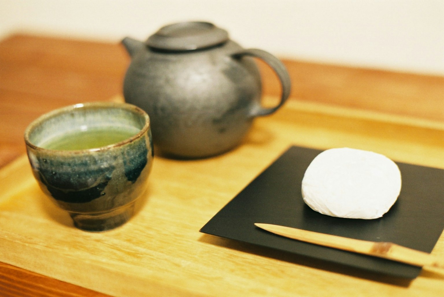 Gambar nampan kayu dengan teh hijau dan kue Jepang