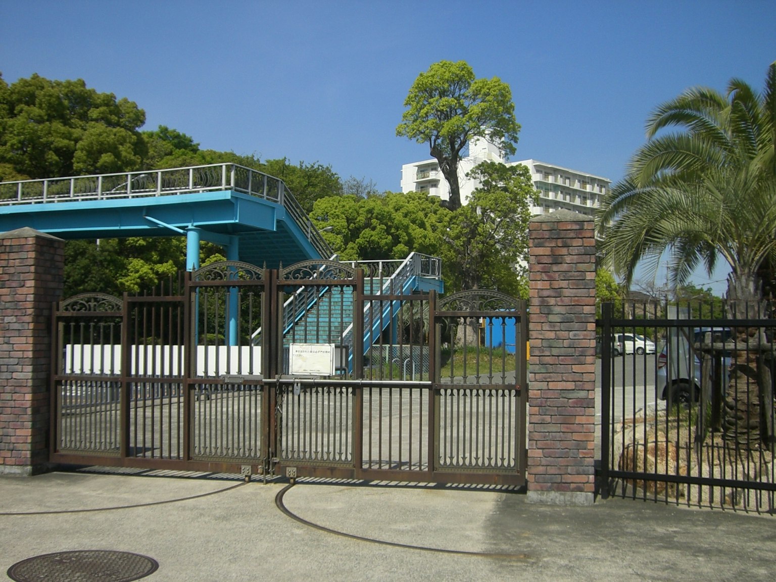公園入口，設有藍色遊樂場和綠色樹木