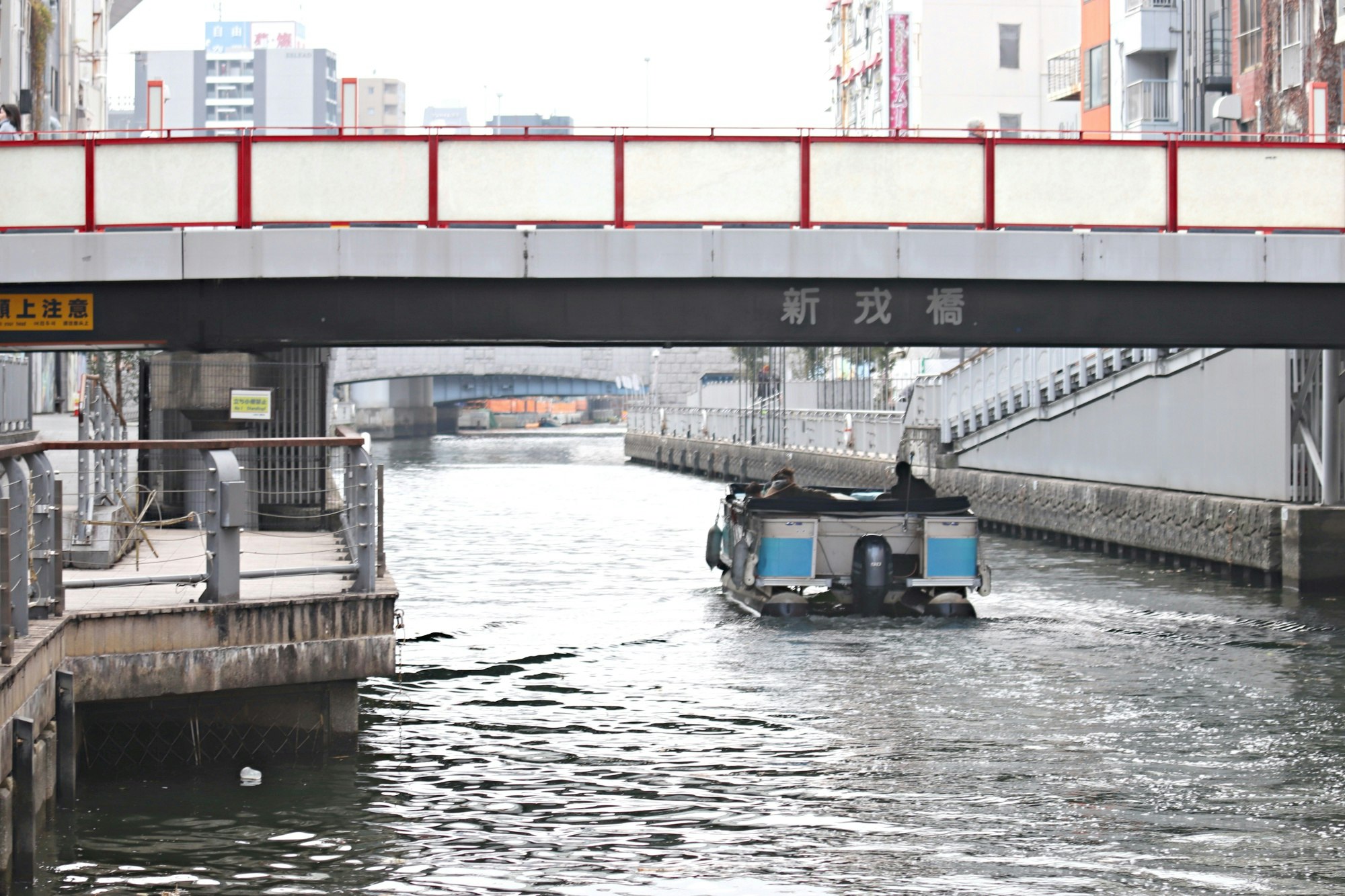 運河橋下行駛的作業船與水面