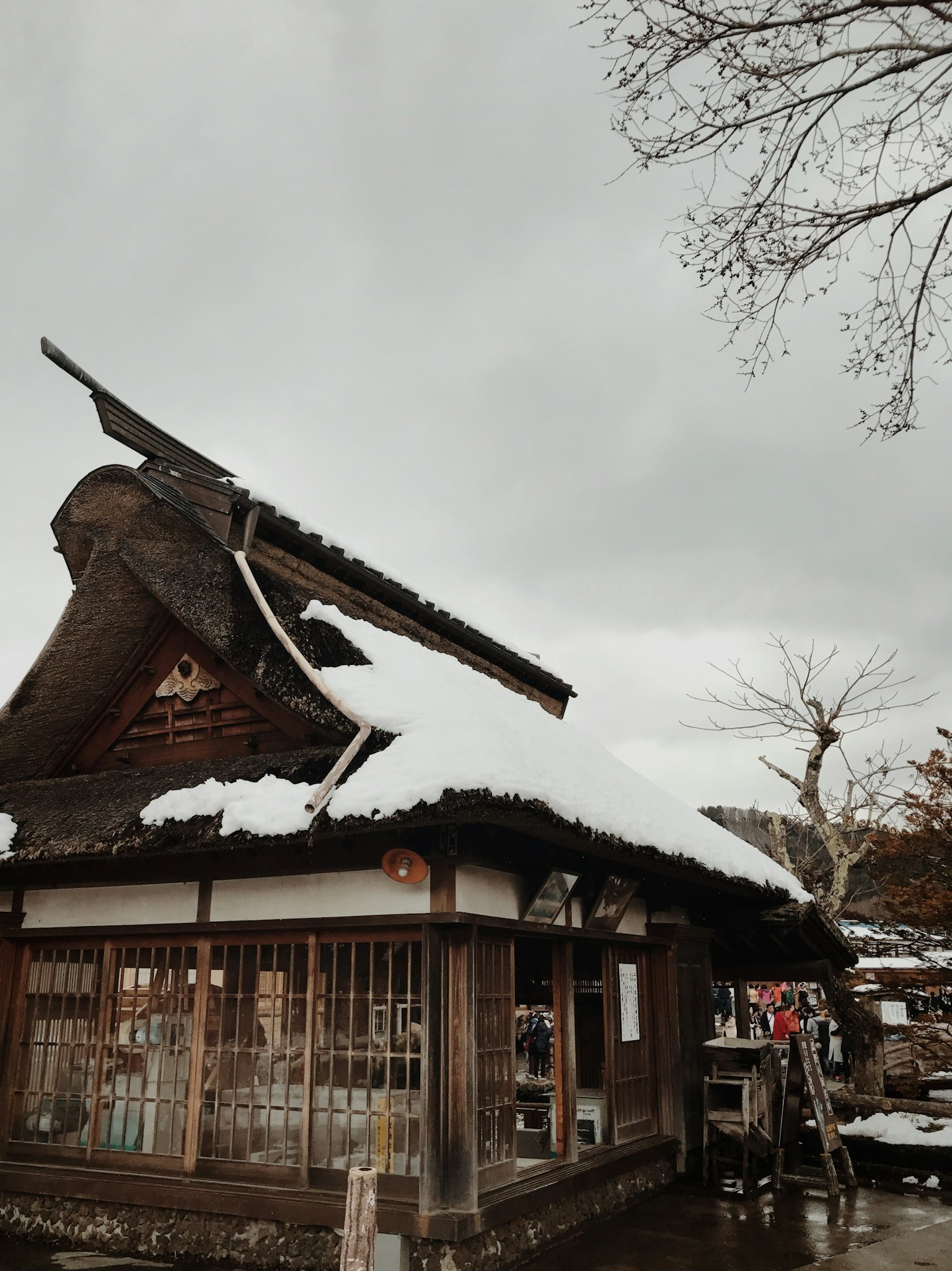 Maison japonaise traditionnelle avec de la neige sur le toit et un ciel nuageux