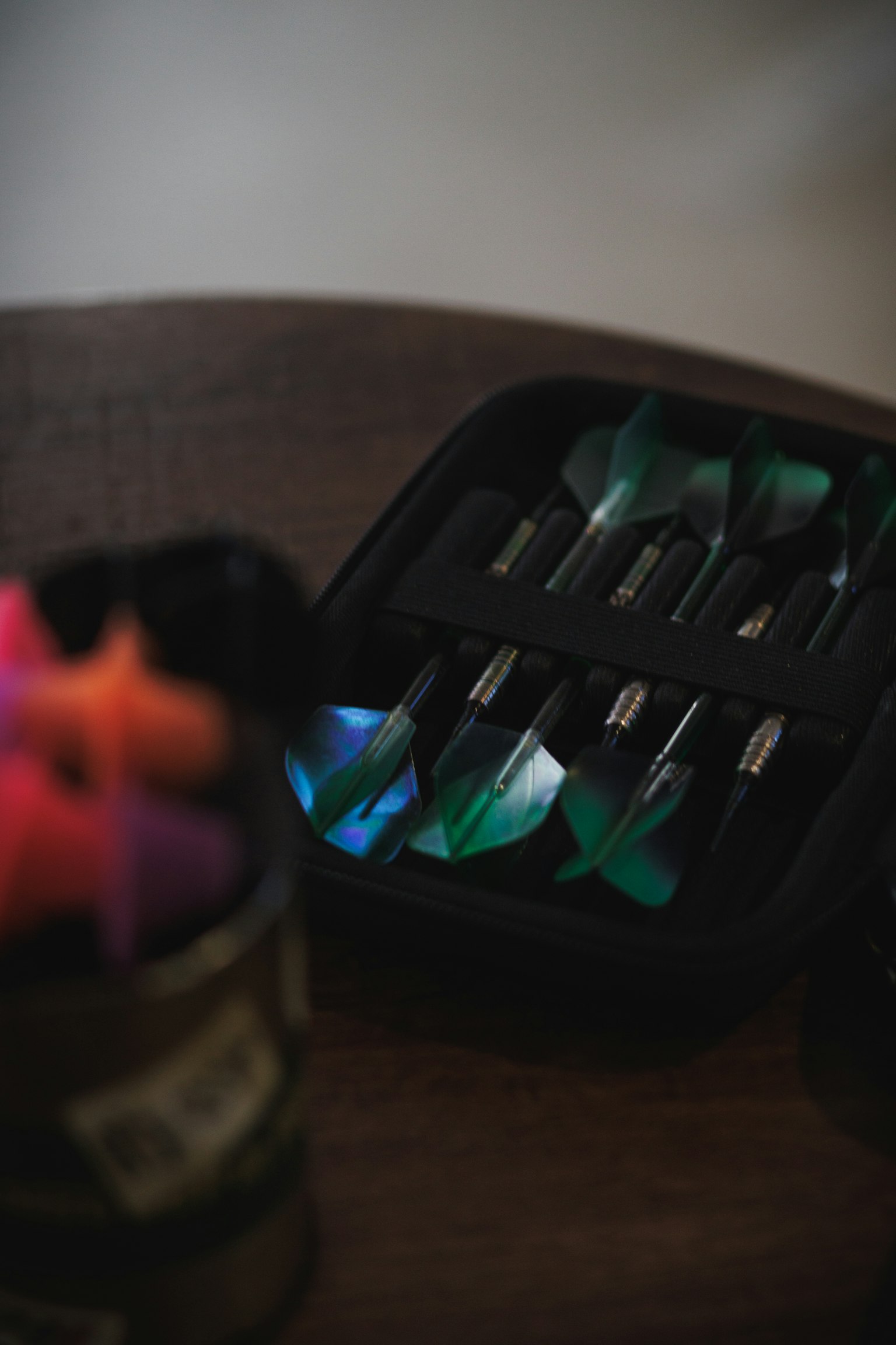 Un ensemble de fléchettes présenté dans un étui noir avec des fléchettes colorées