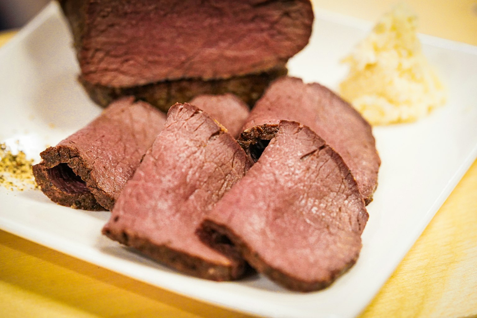 Rebanadas de carne asada servidas con wasabi en un plato