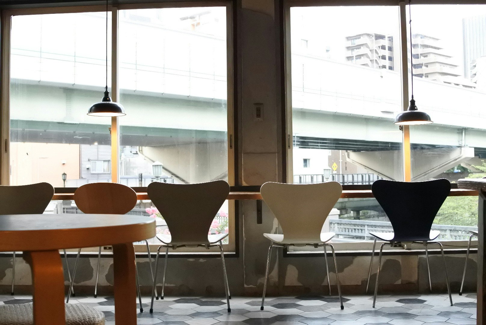 moderne Bürotische und -stühle neben großen Fenstern